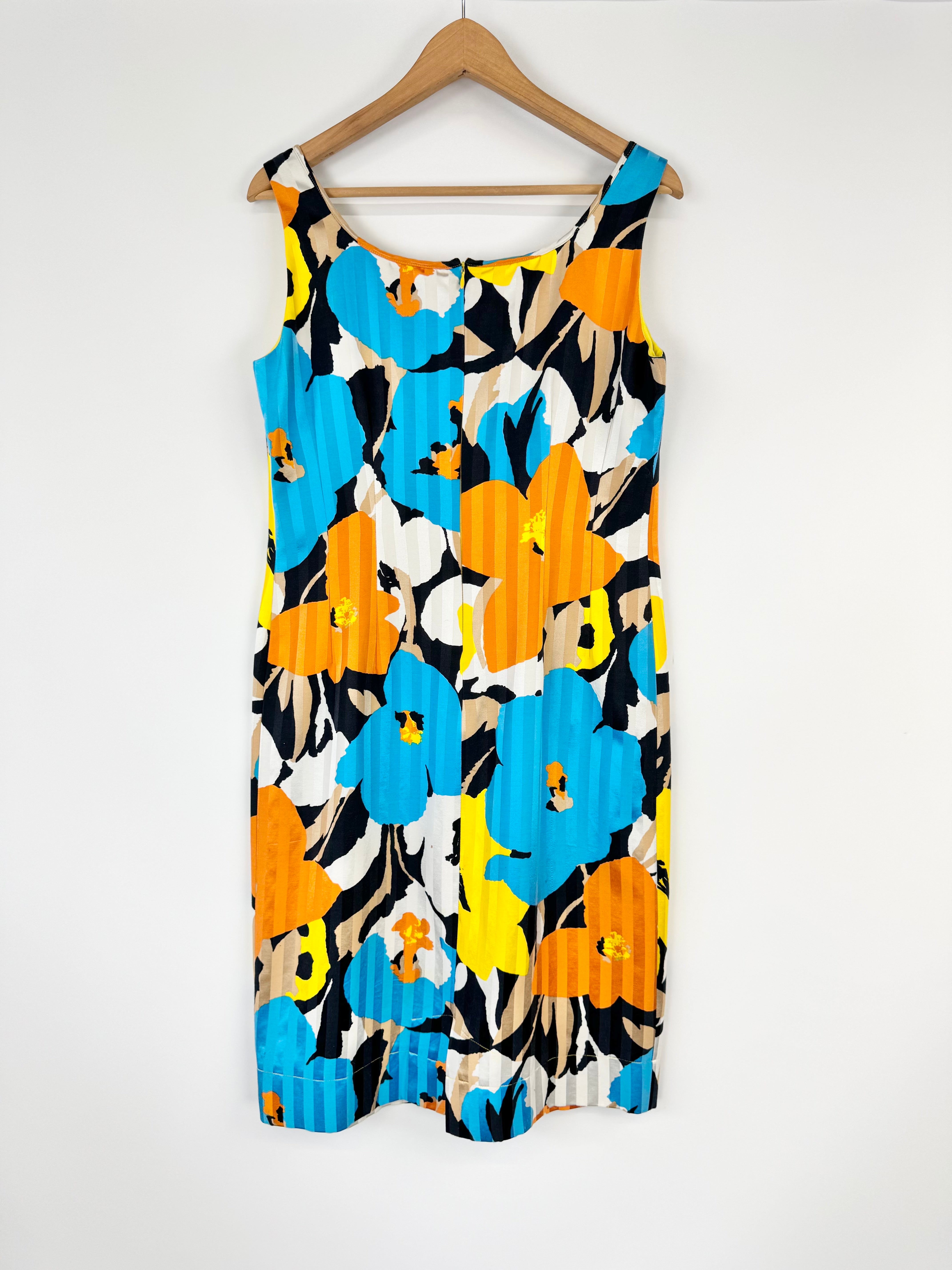 Colorful floral dress on a hanger against a white background