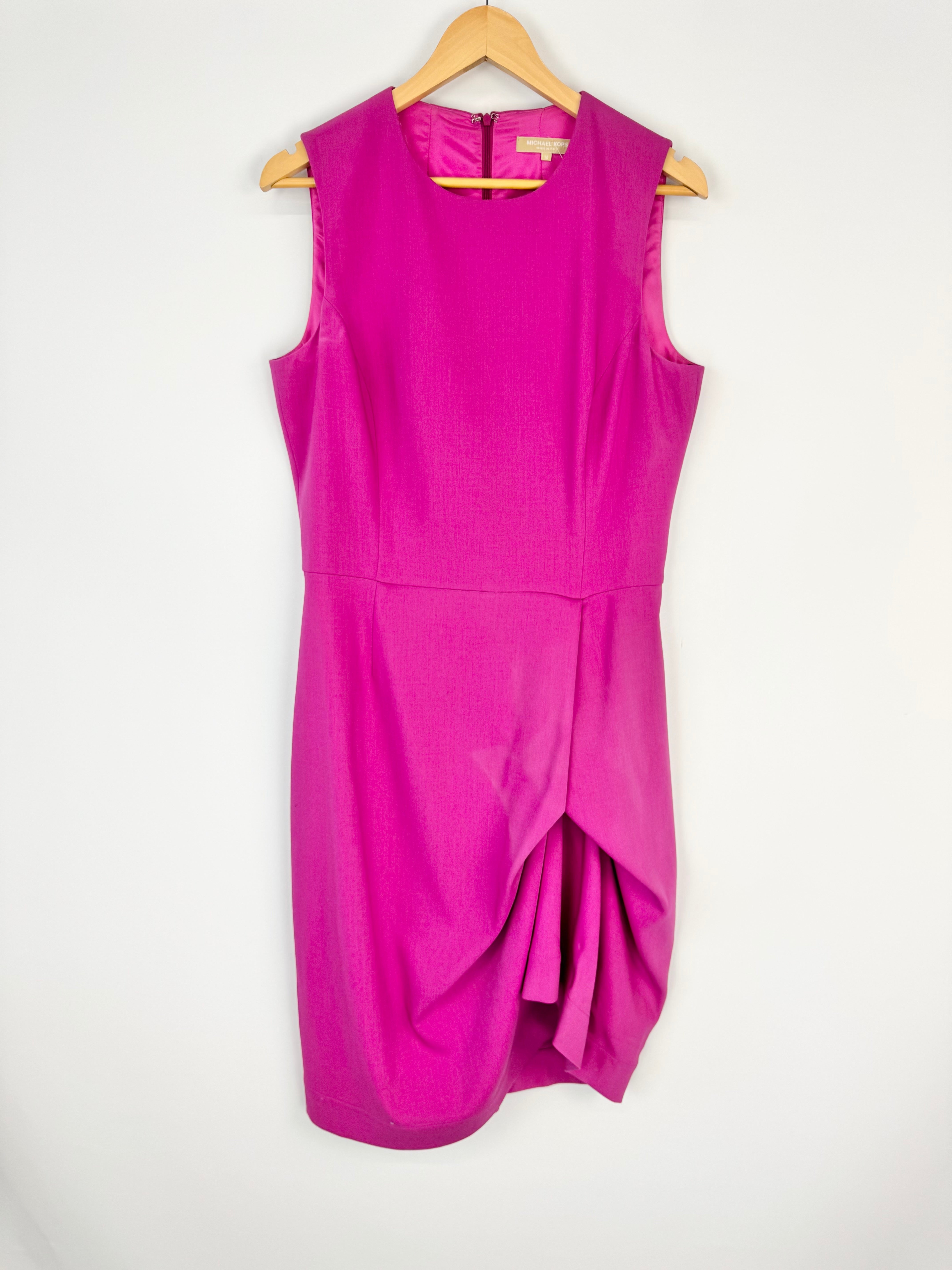 Pink sleeveless dress on a hanger against a white background