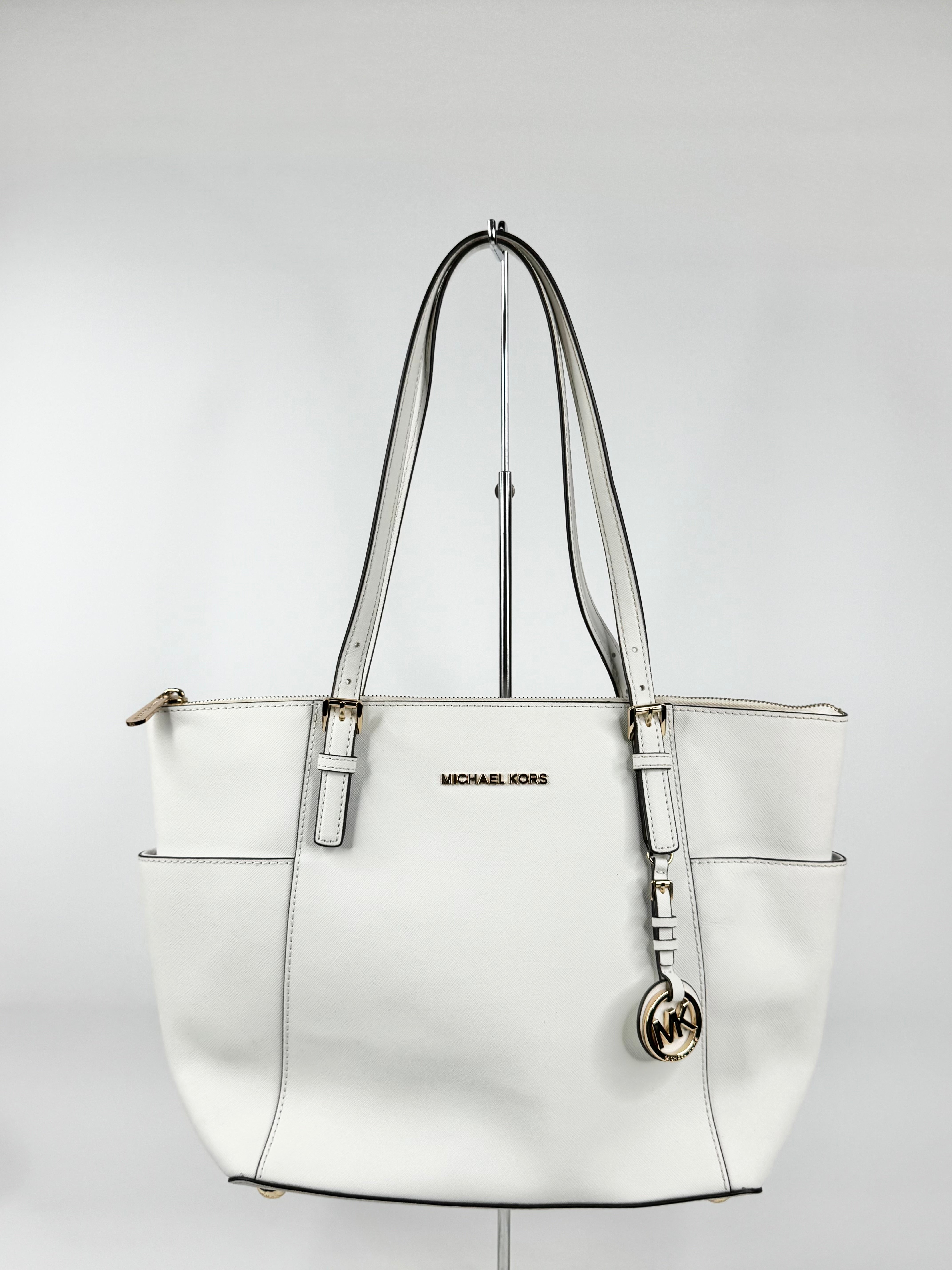 White handbag with visible brand logo on a light gray background