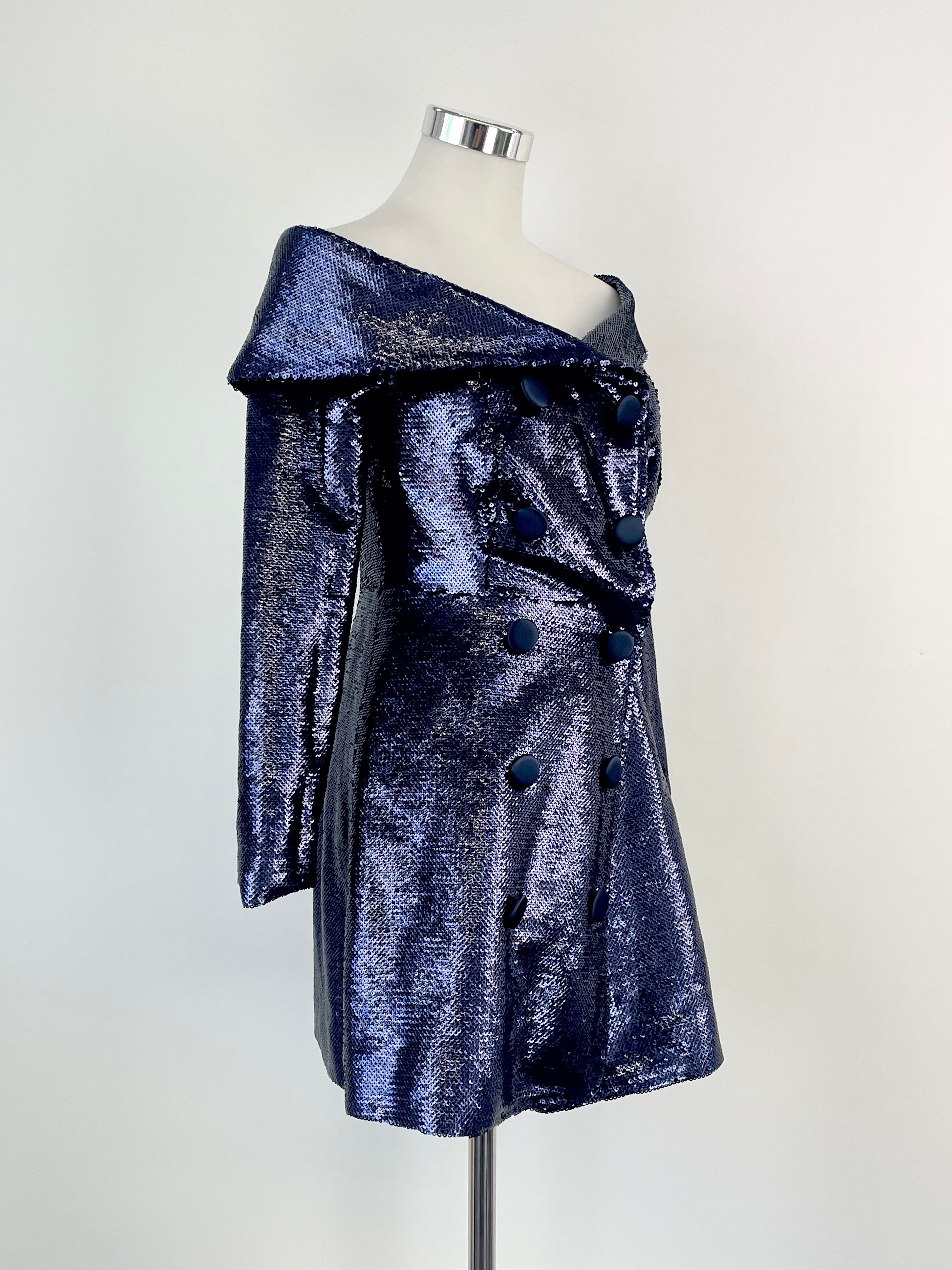 A sequined violet coat with wide lapels and an off-shoulder neckline displayed on a mannequin.