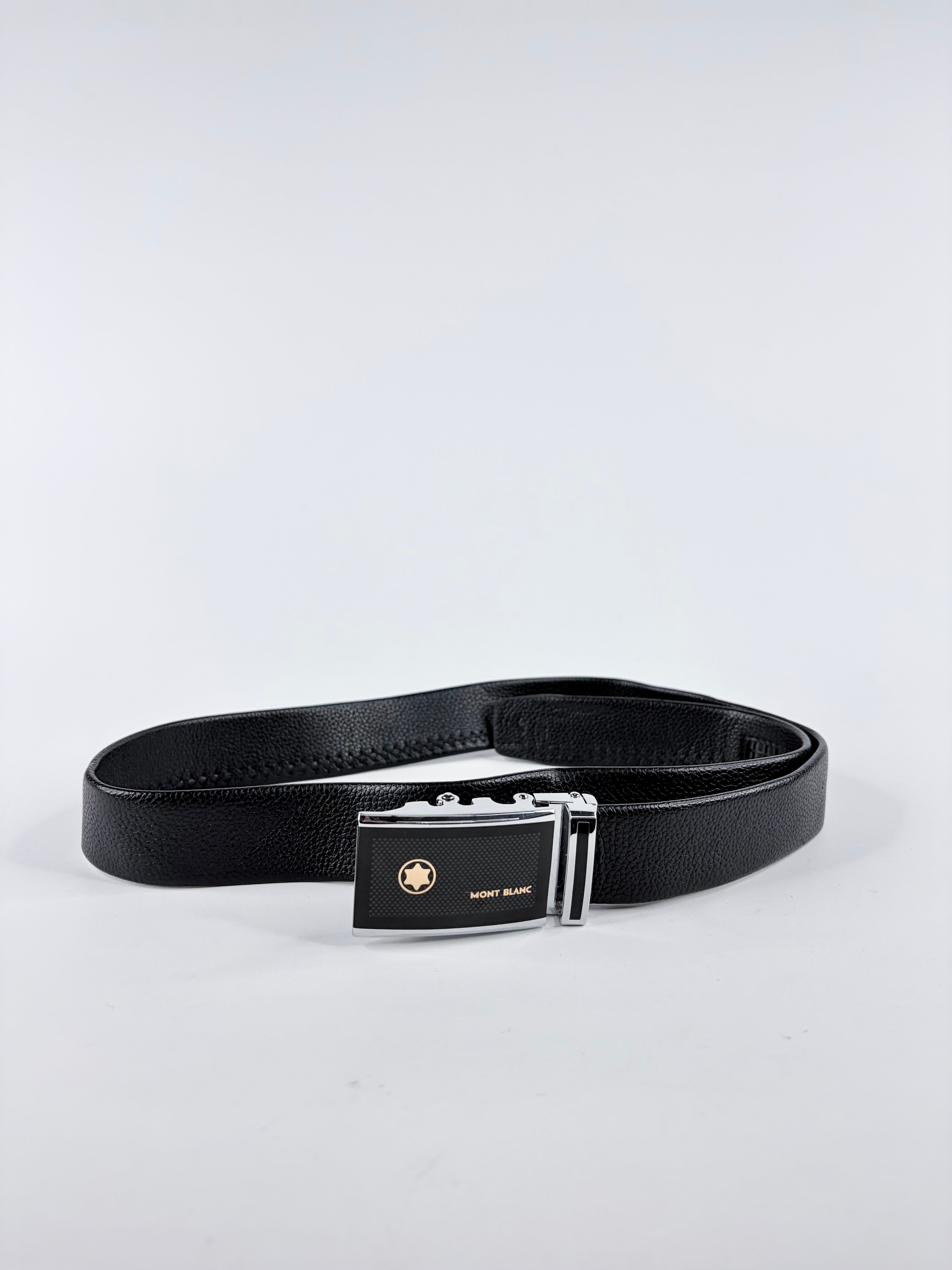 Black belt with a silver buckle on a light gray background