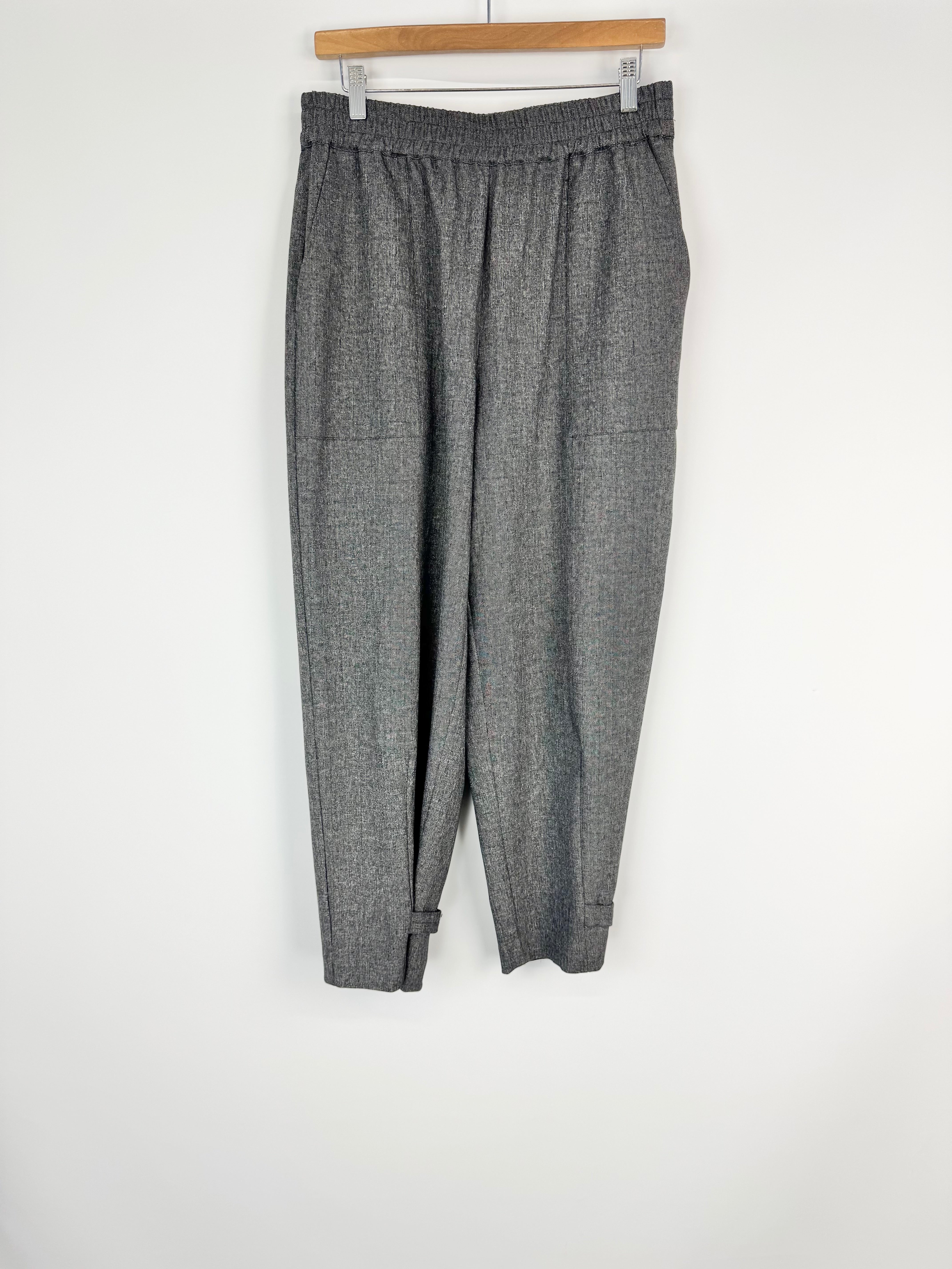 Gray checkered pants hanging on a wooden hanger against a white background