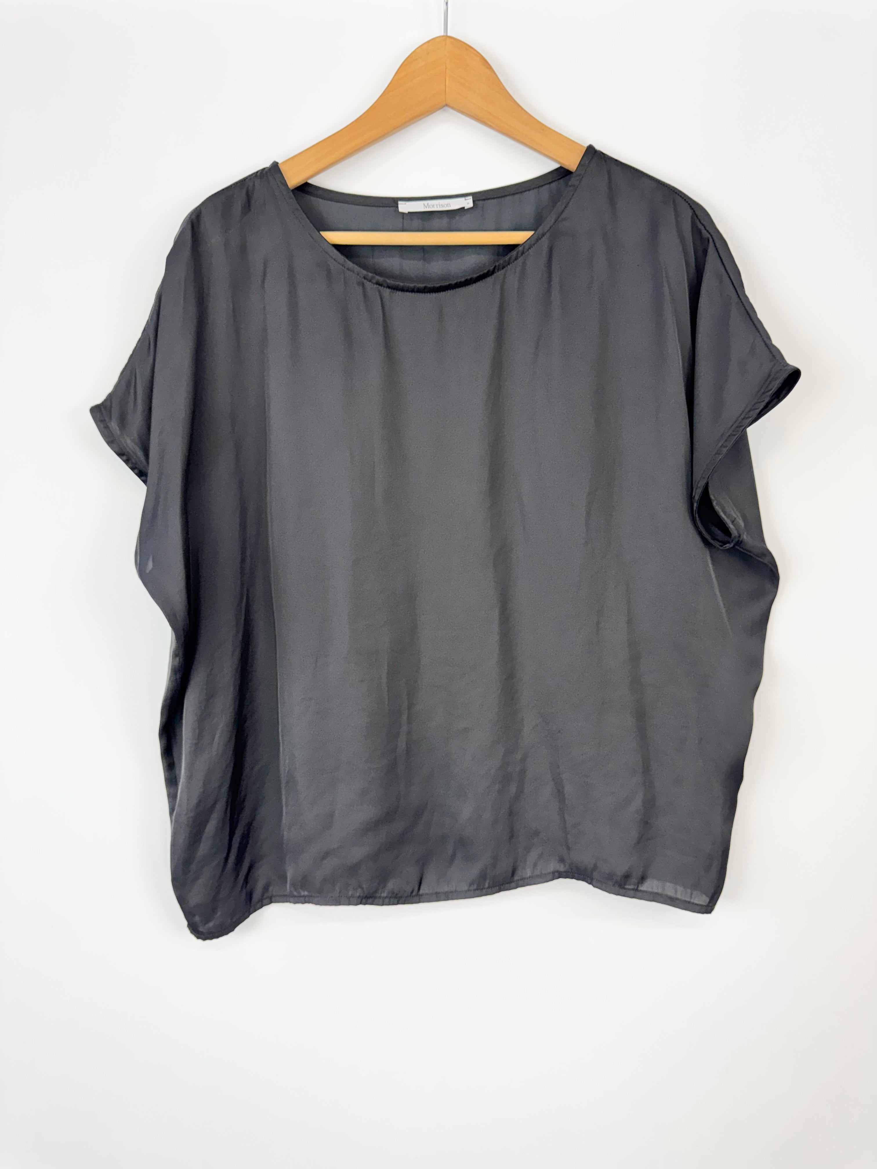 Gray blouse on a wooden hanger against a white background