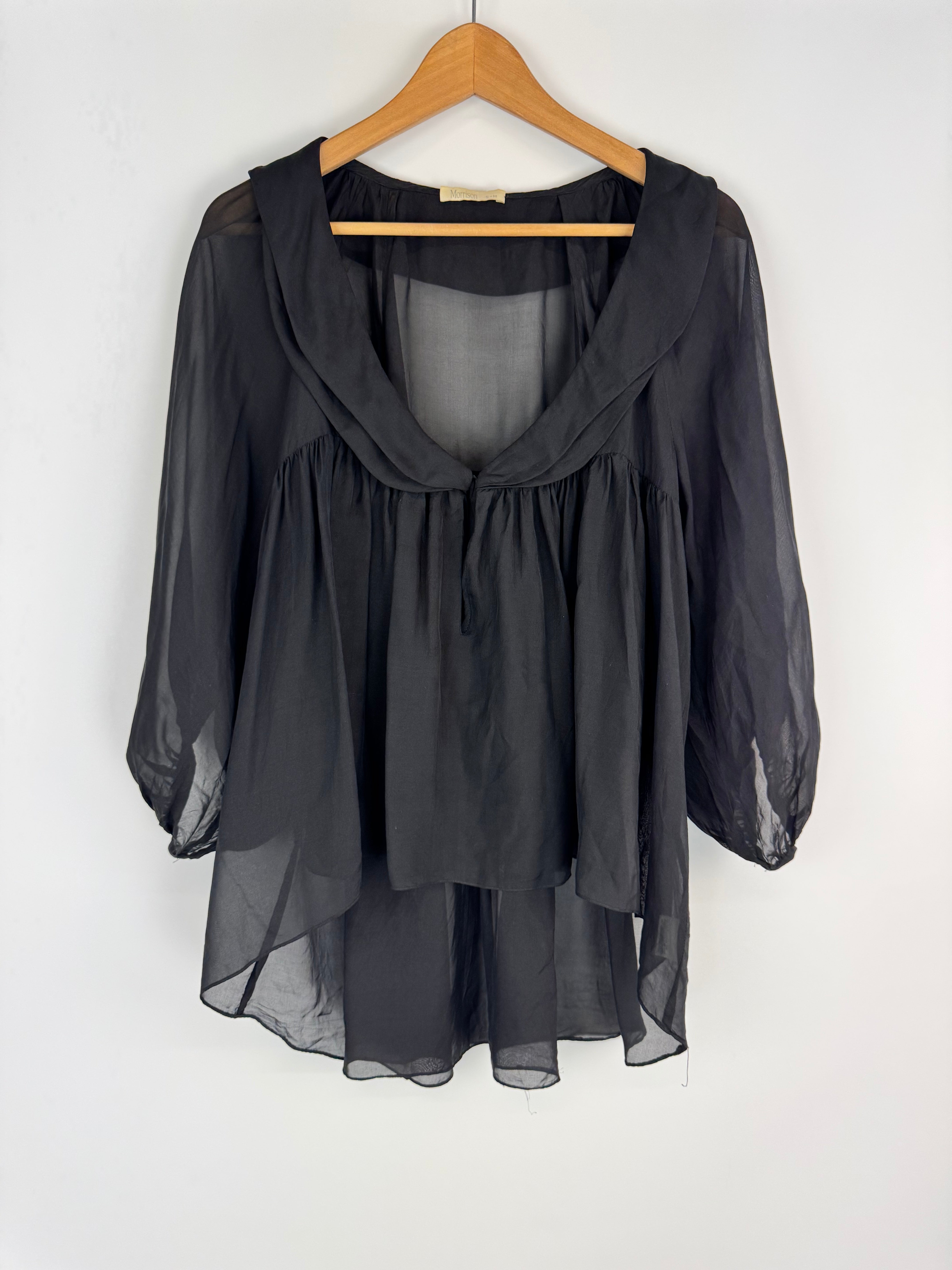 Black sheer dress on a wooden hanger against a white background