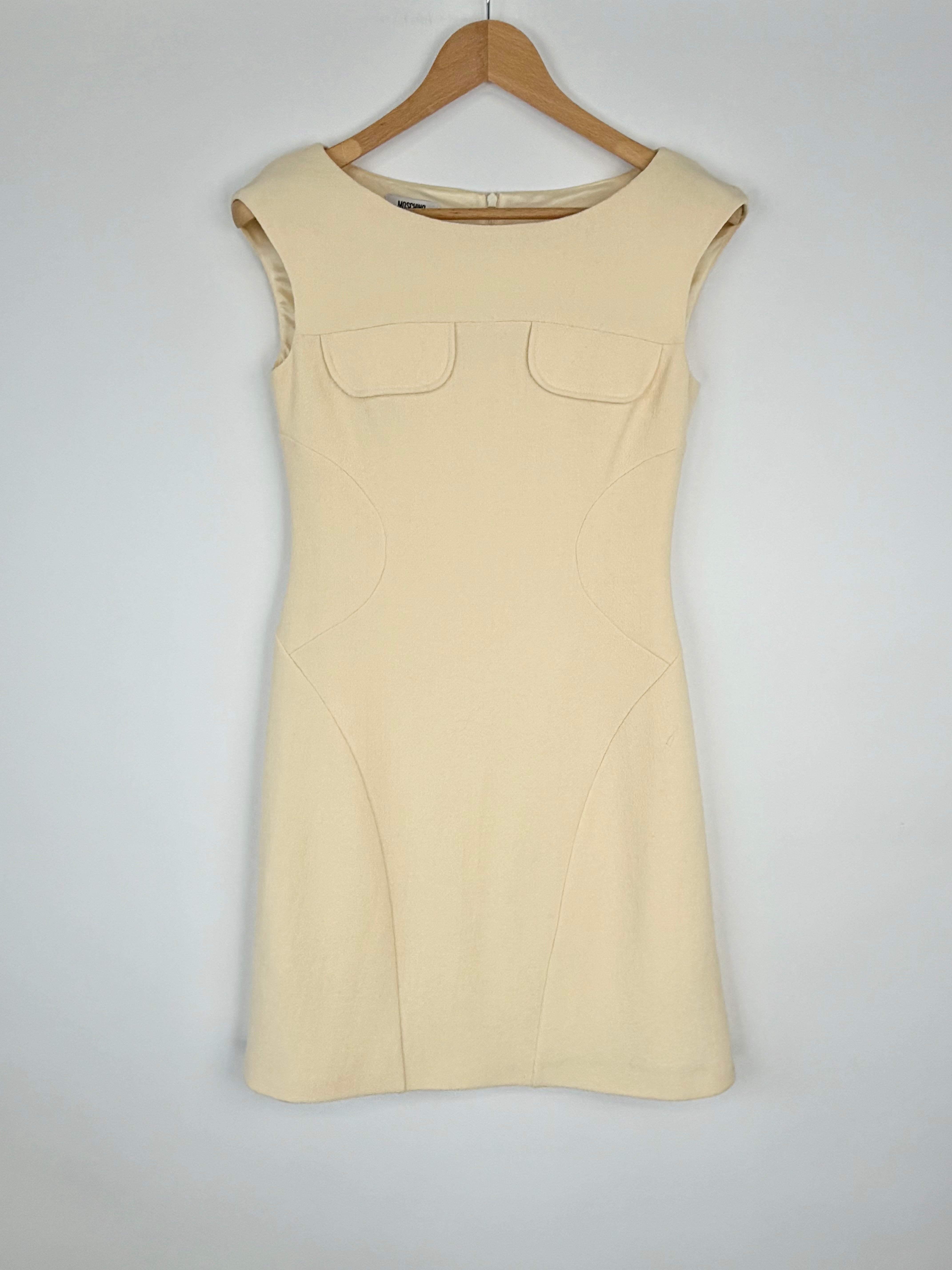 Beige sleeveless dress on a wooden hanger against a white background