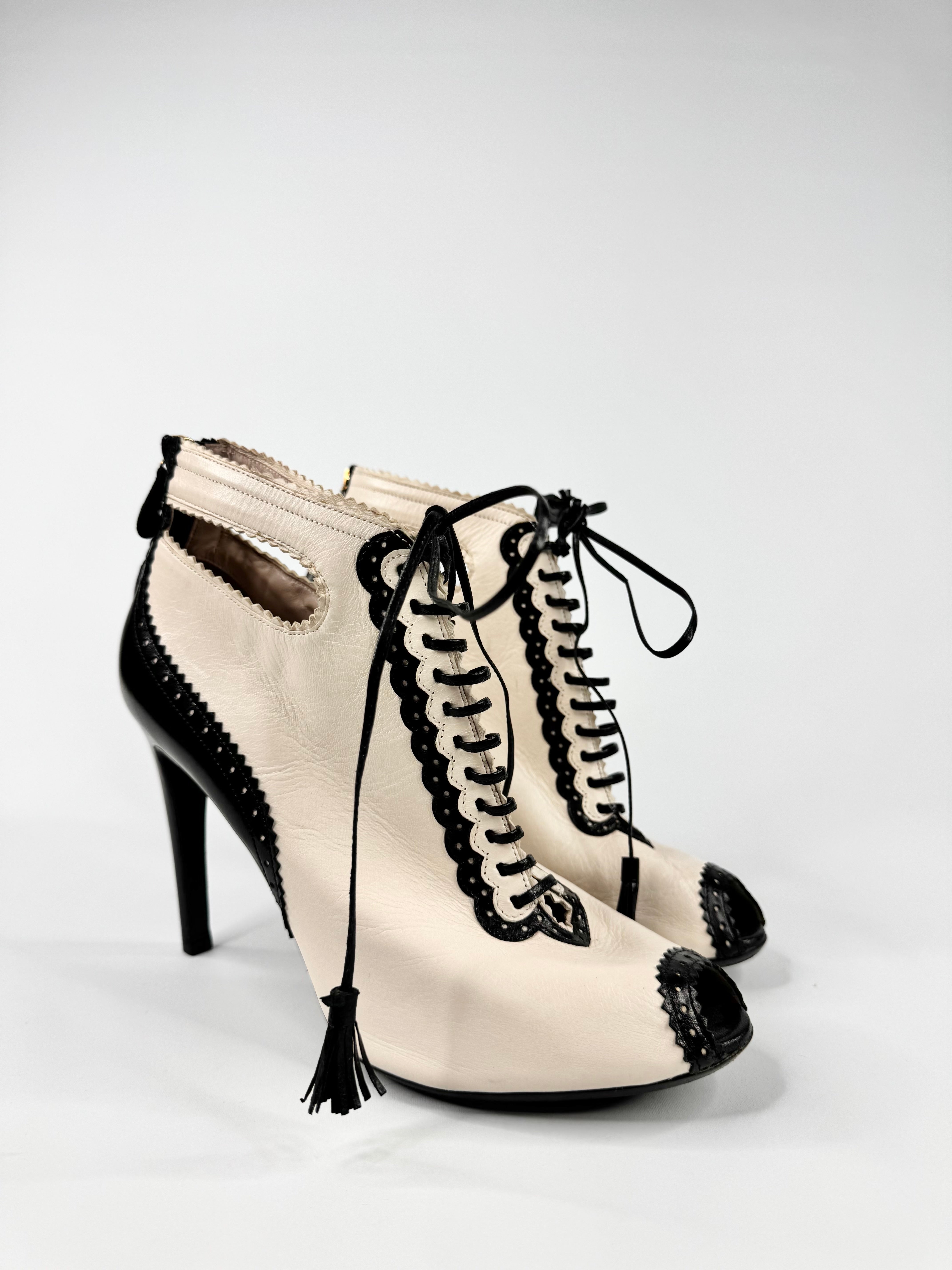 Pair of high-heeled shoes with black lace detailing on a white background
