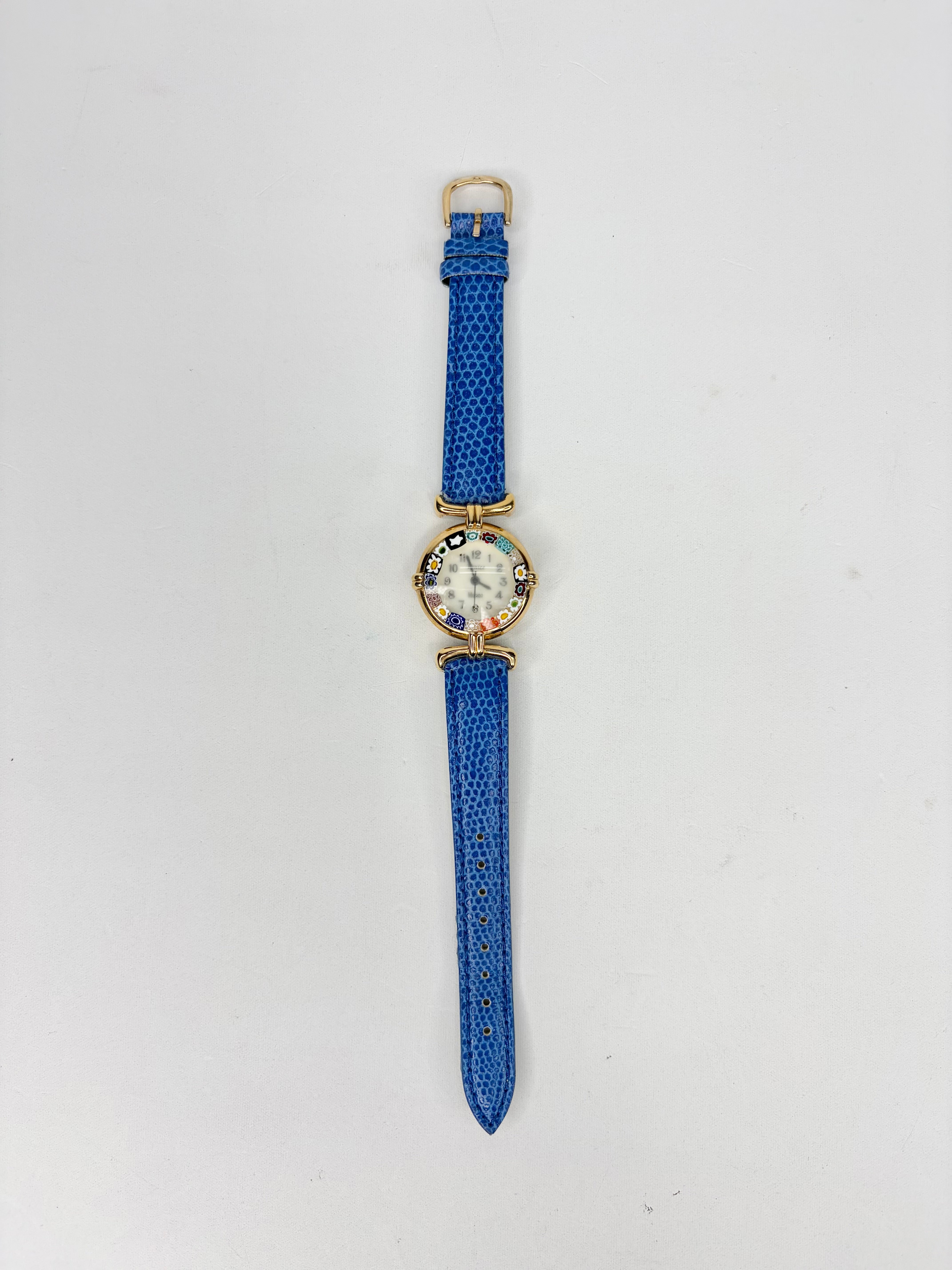Watch with a blue strap on a light gray background