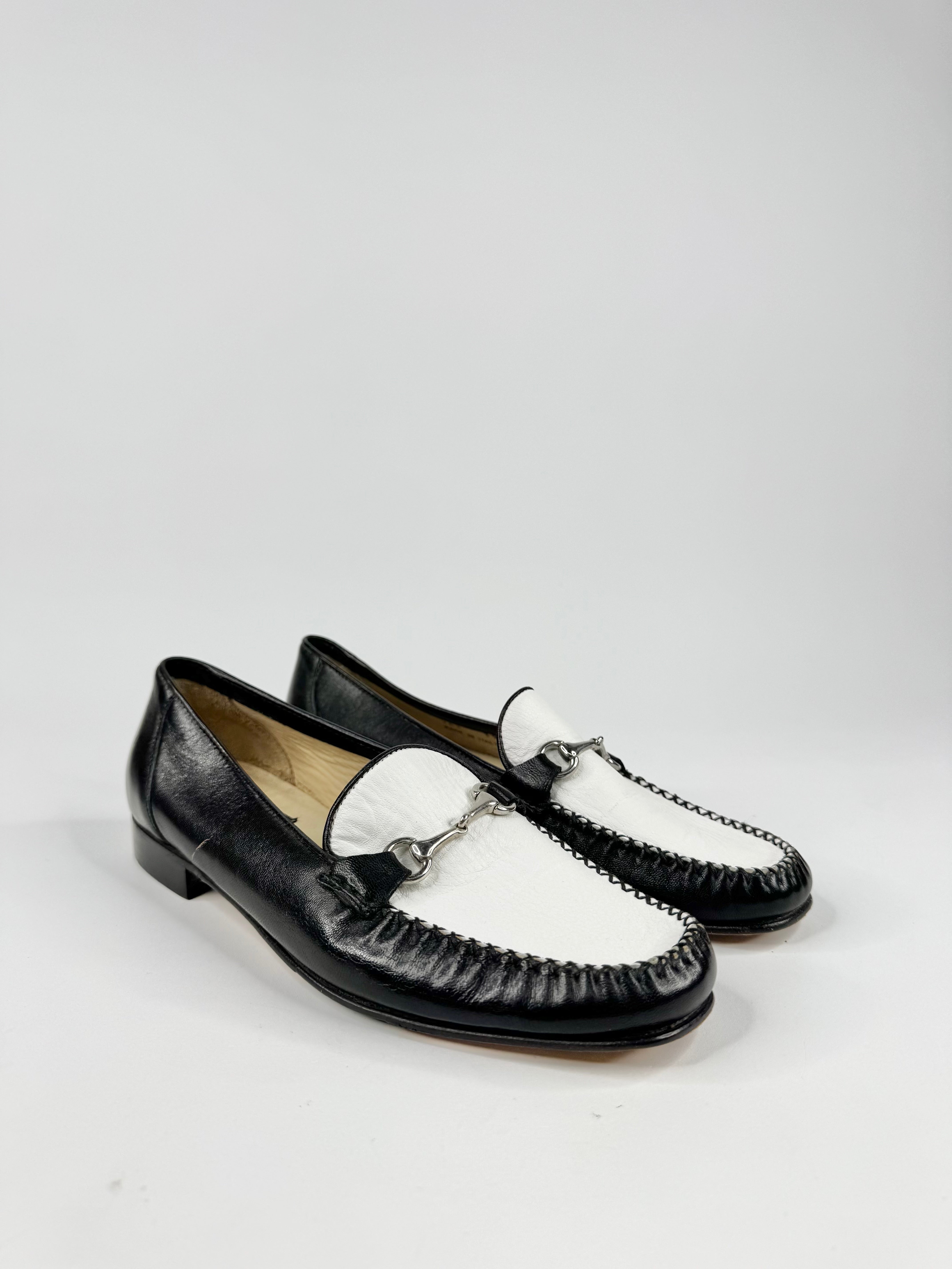 Black and white loafers on a light gray background