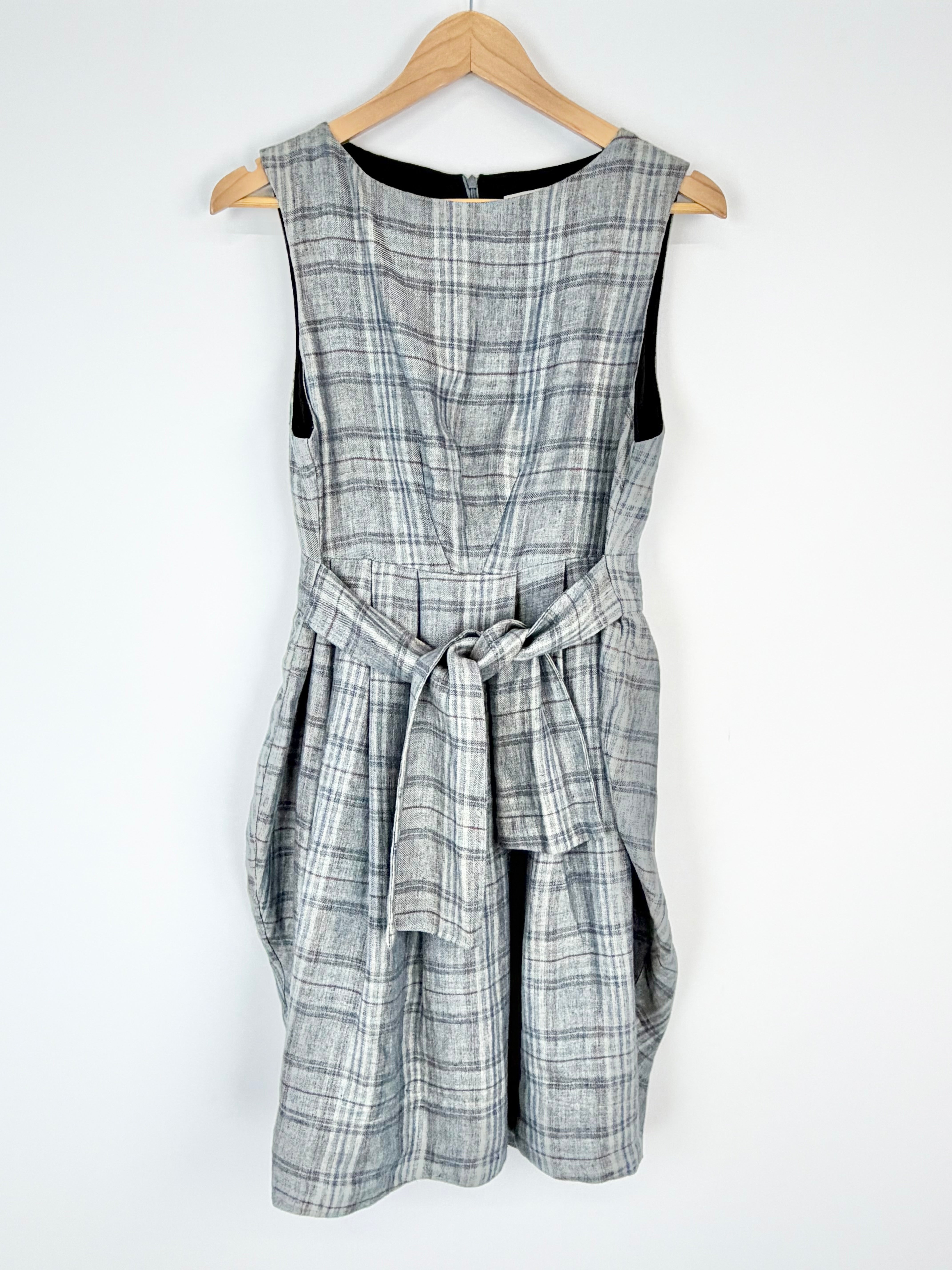 Plaid dress on a wooden hanger against a white background