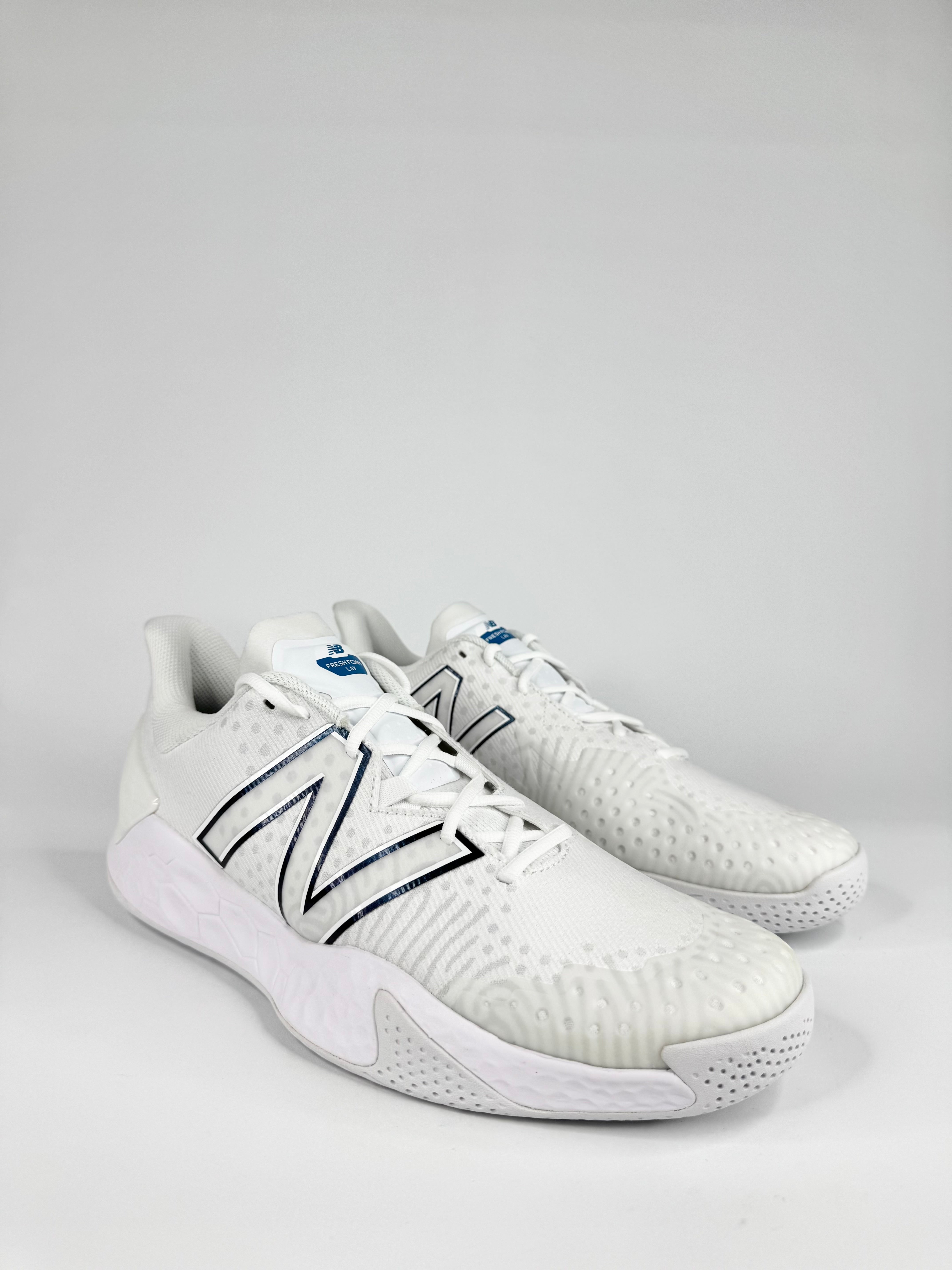 White sneakers with black logo on a light gray background