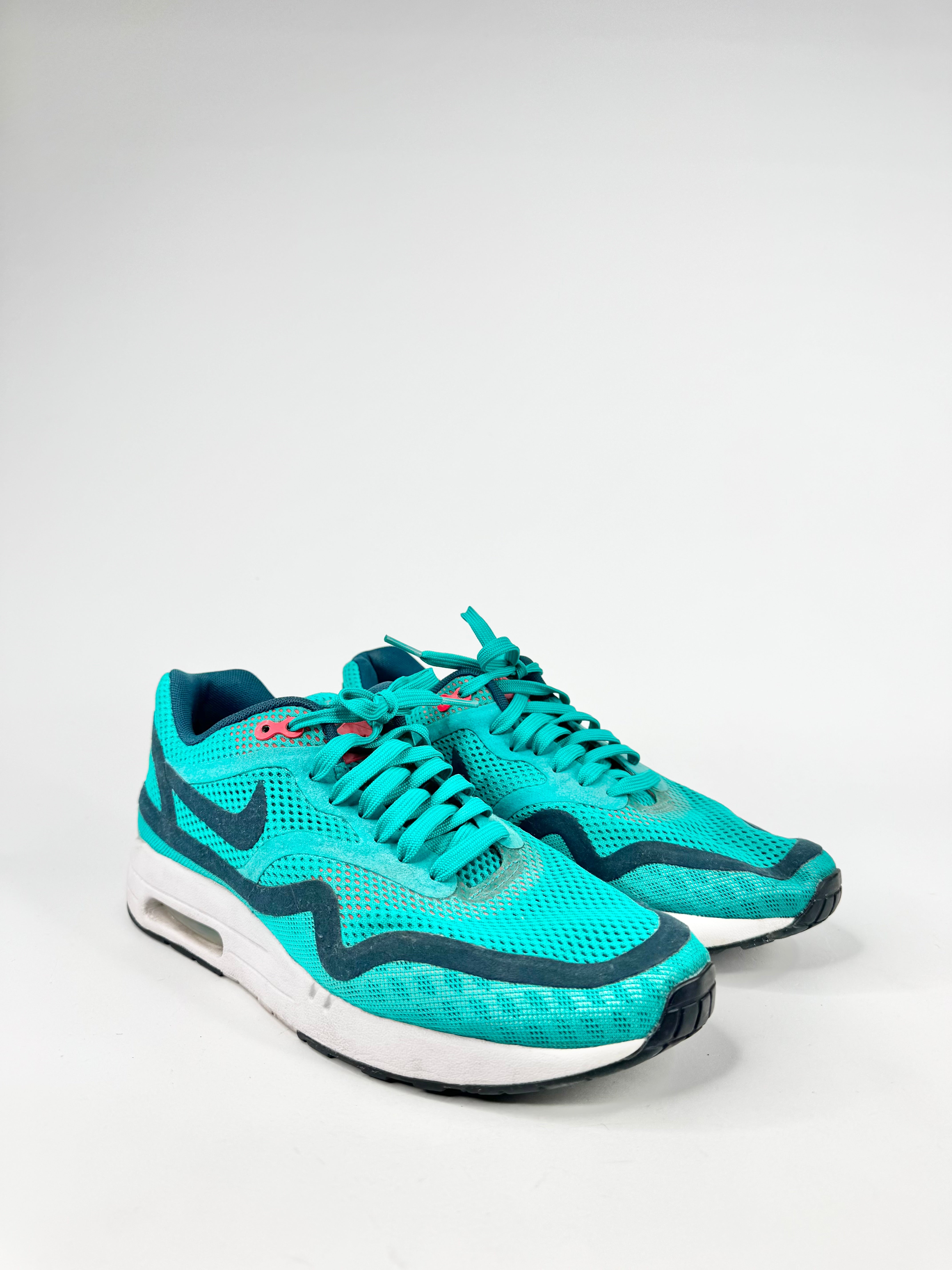 Pair of turquoise running shoes on a light gray background