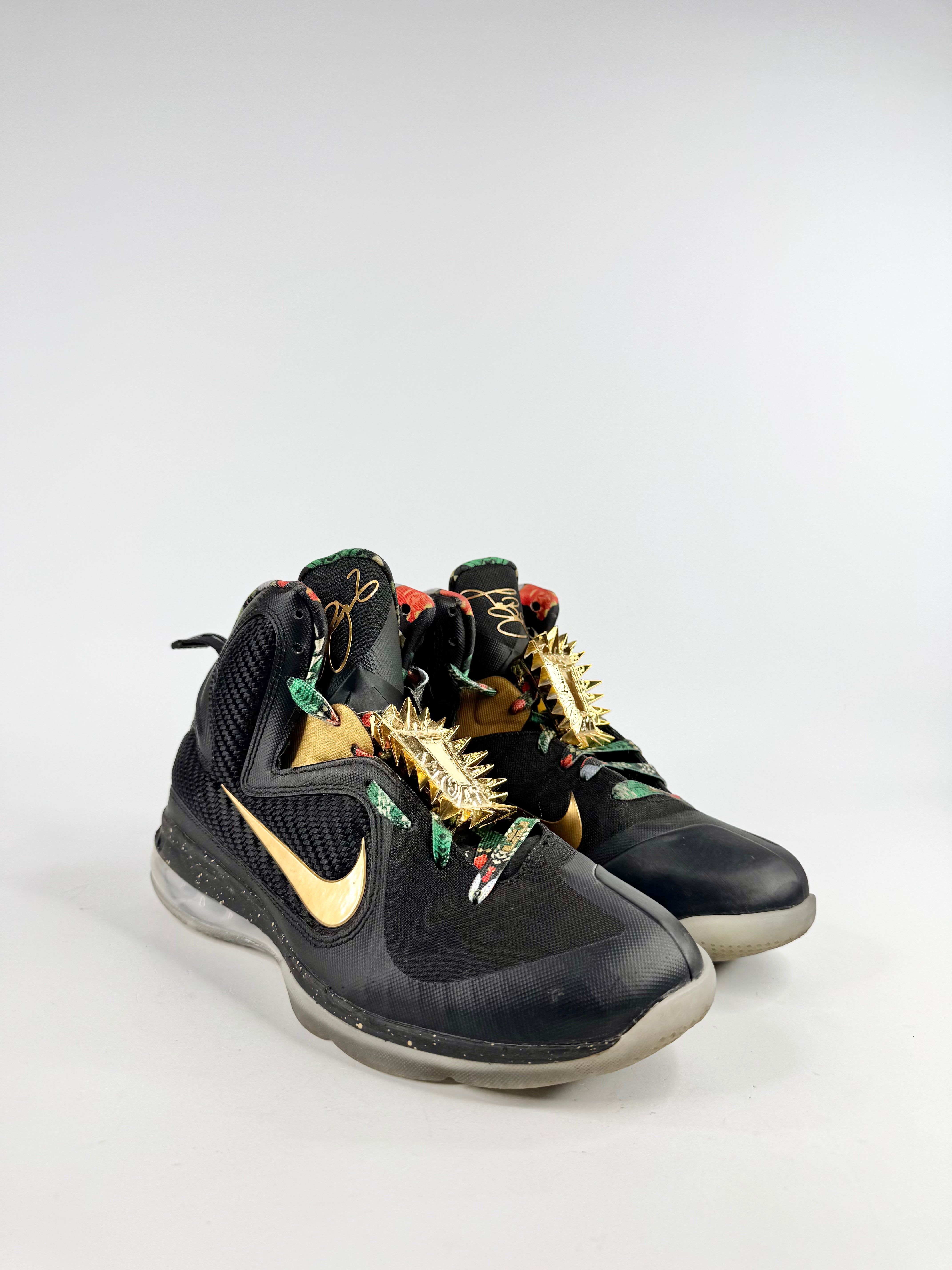 Black sneakers with gold accents and unique design elements on a white background
