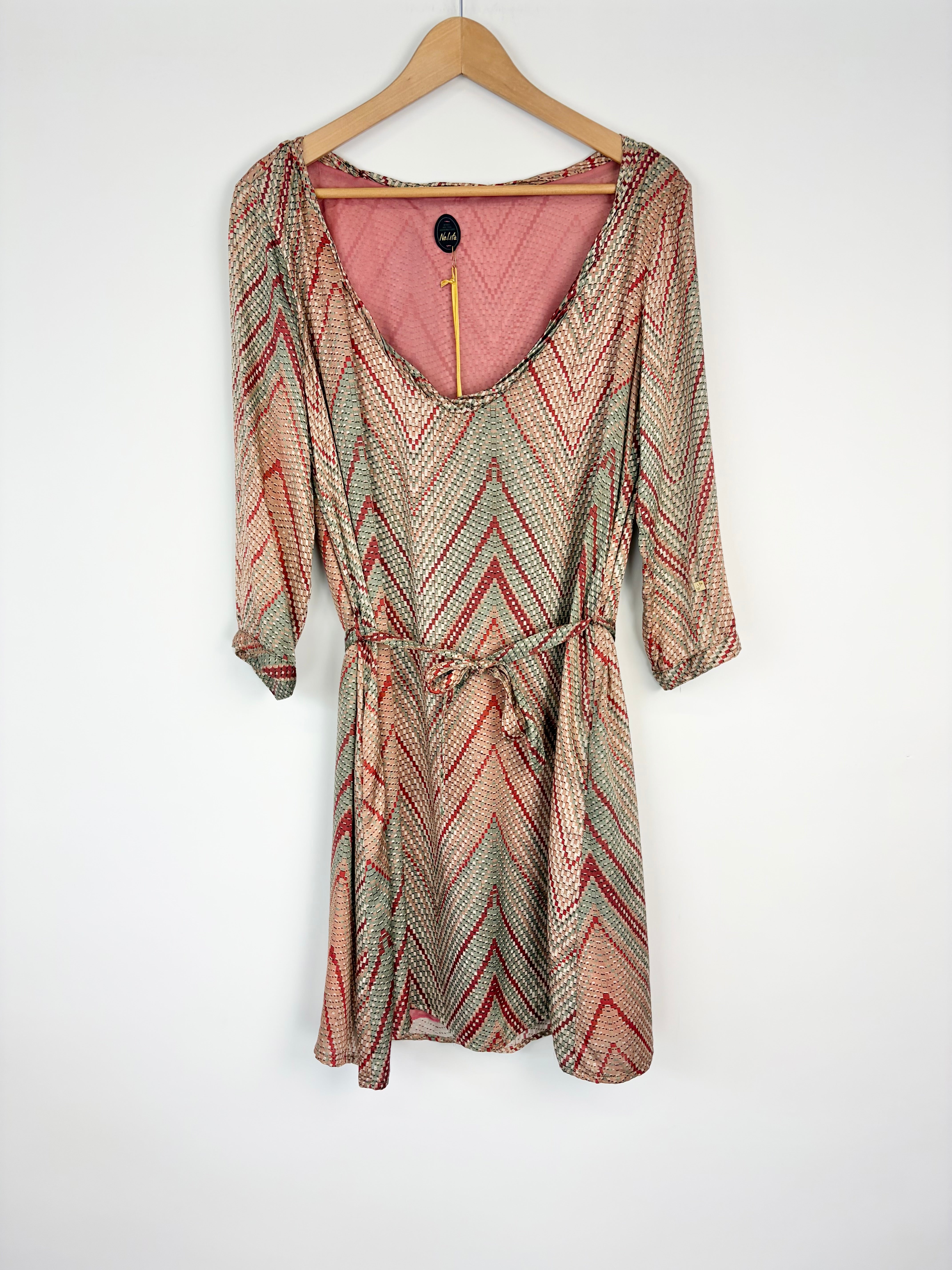 Patterned dress on a hanger against a white background
