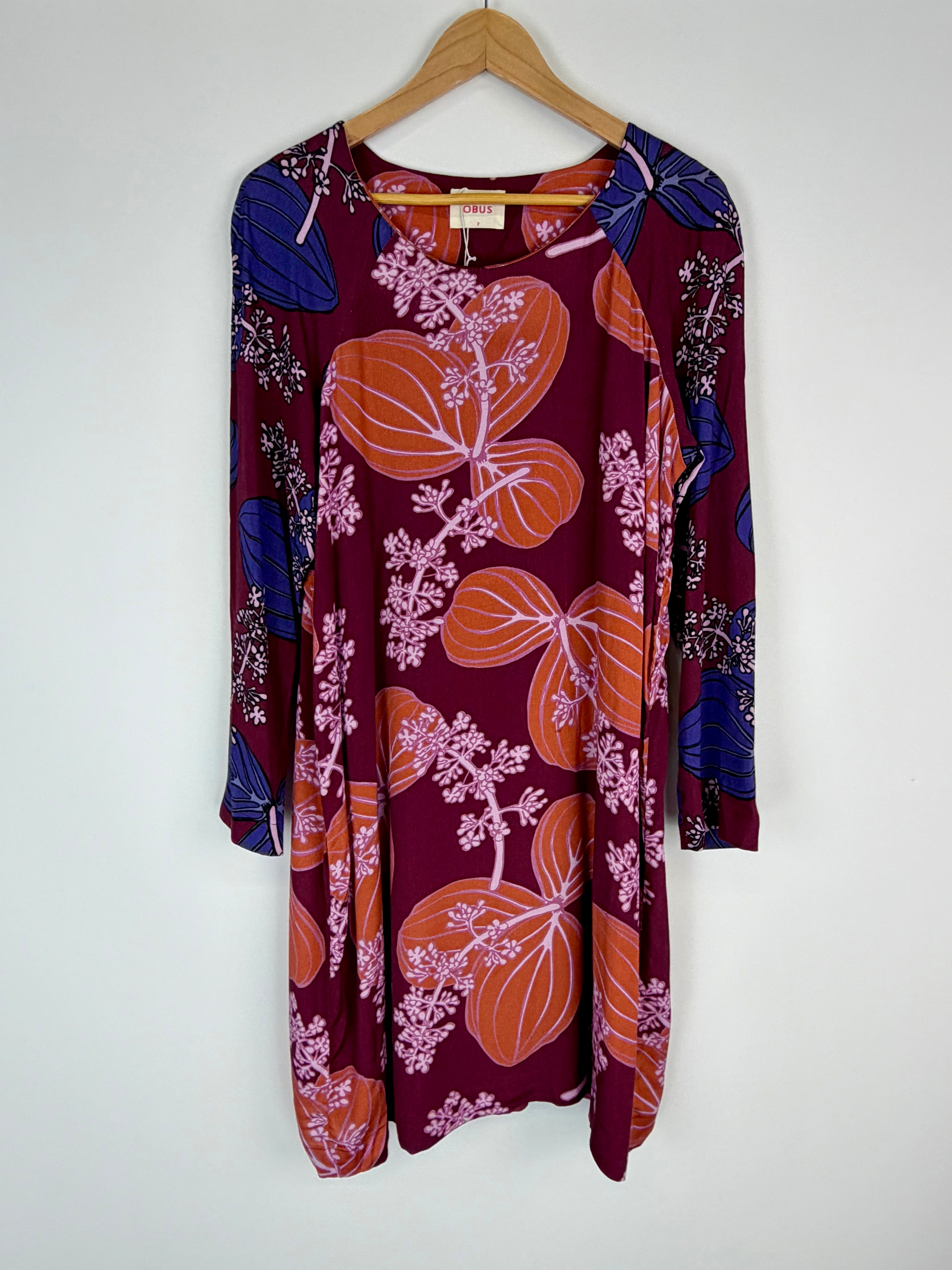Floral-patterned dress on a hanger against a white background