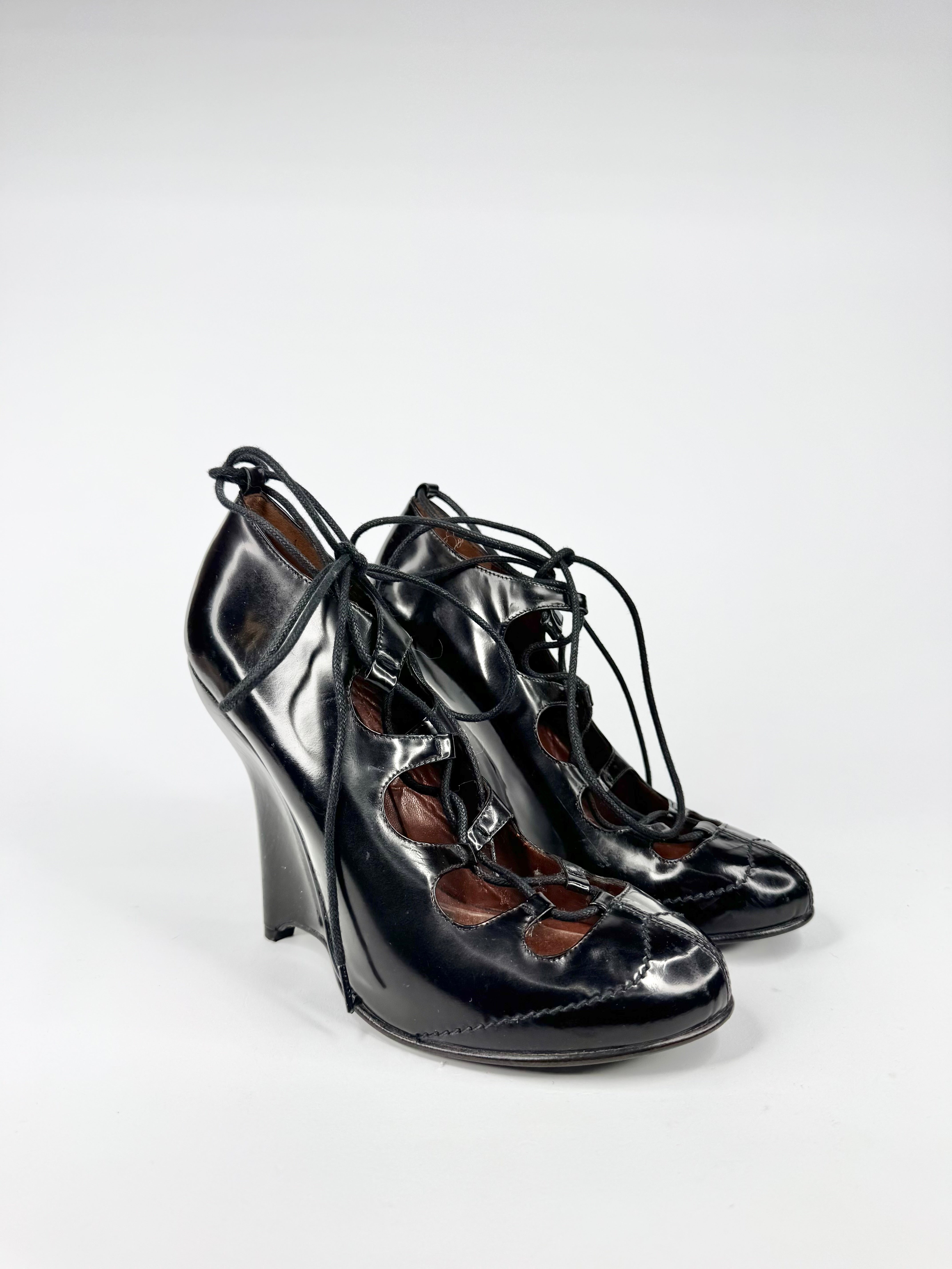 Black high-heeled shoes with brown accents on a white background