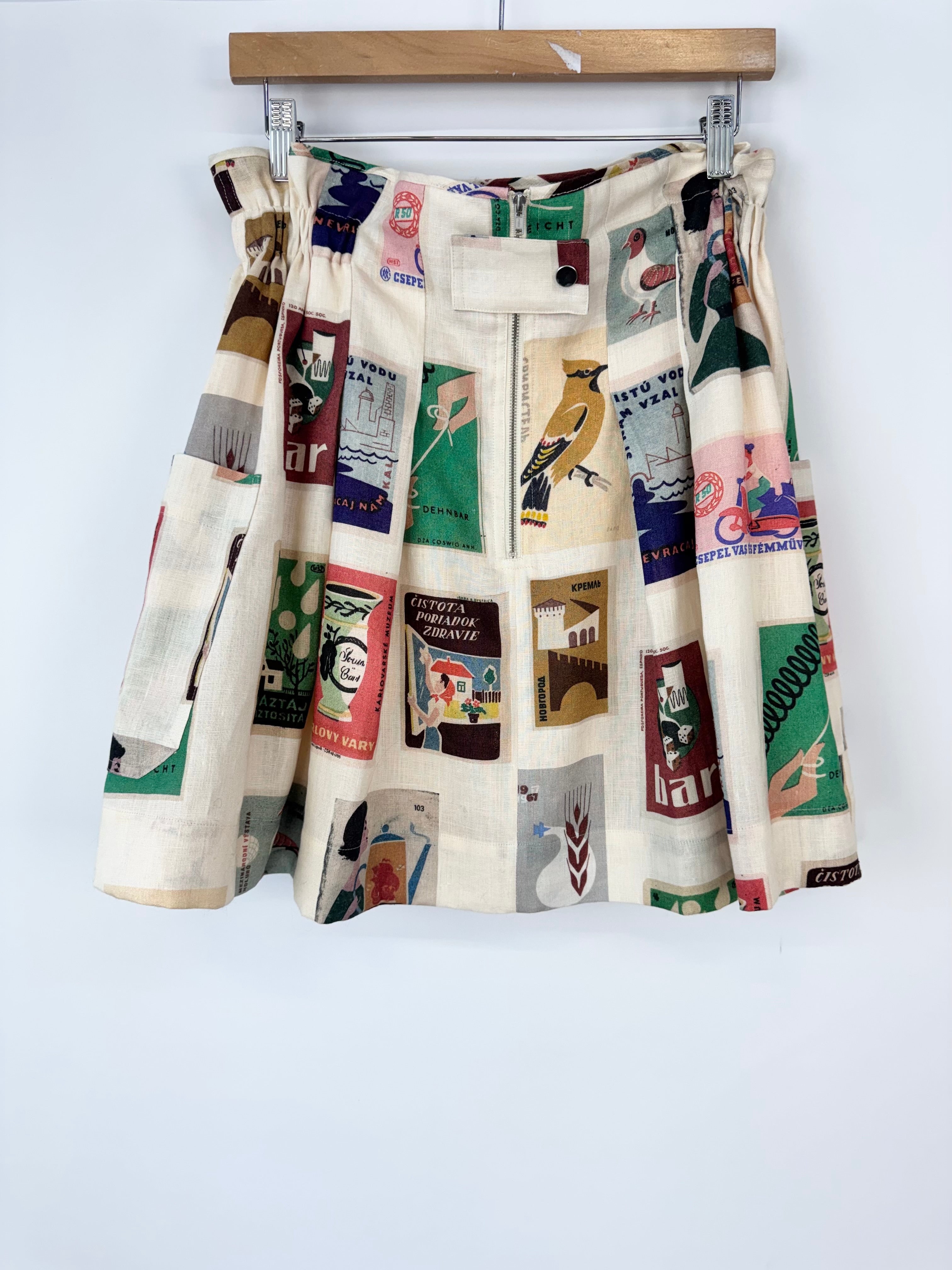 Skirt with vintage book cover pattern hanging on a rack against a white background