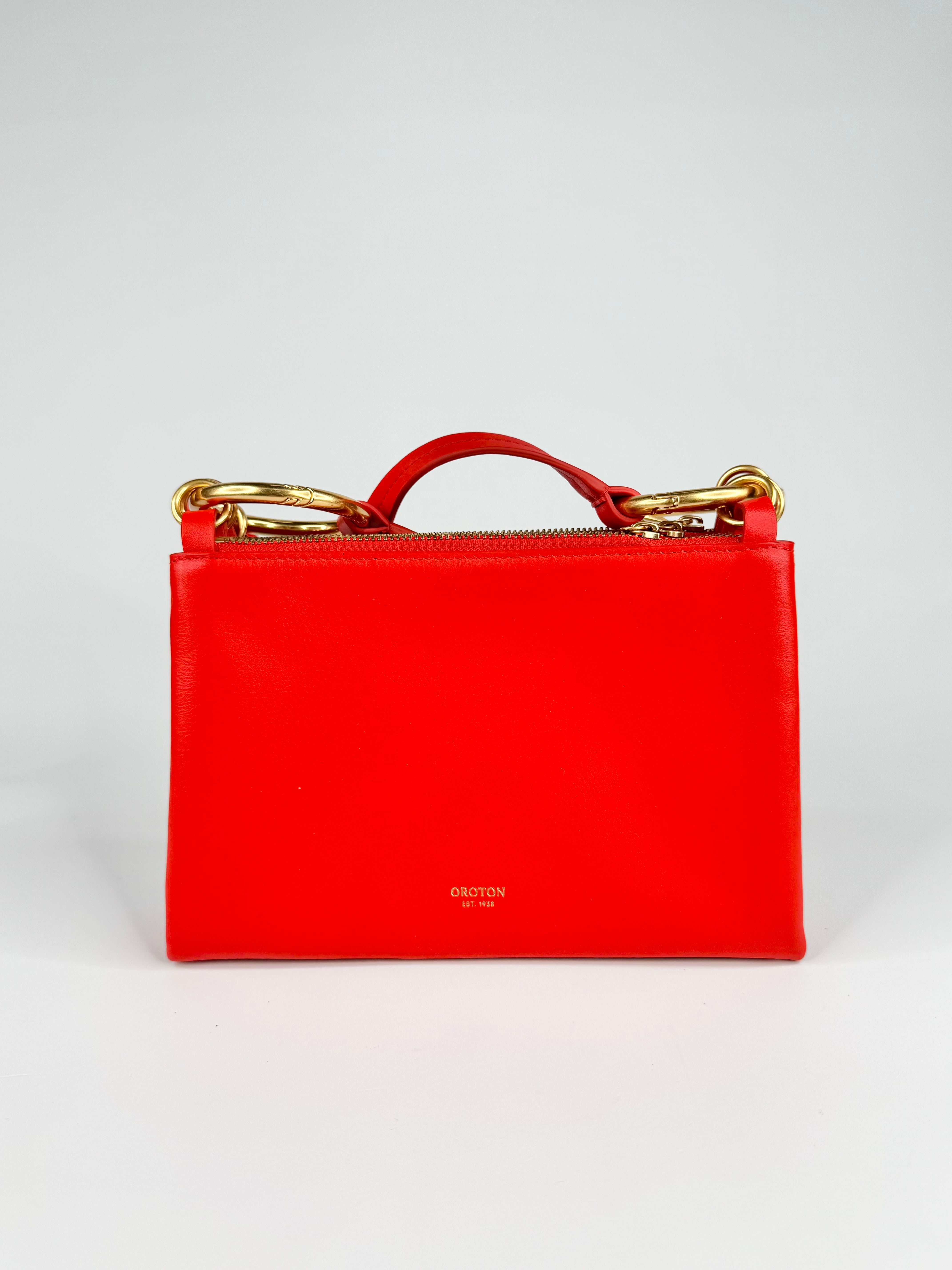 Red handbag with gold accents on a white background