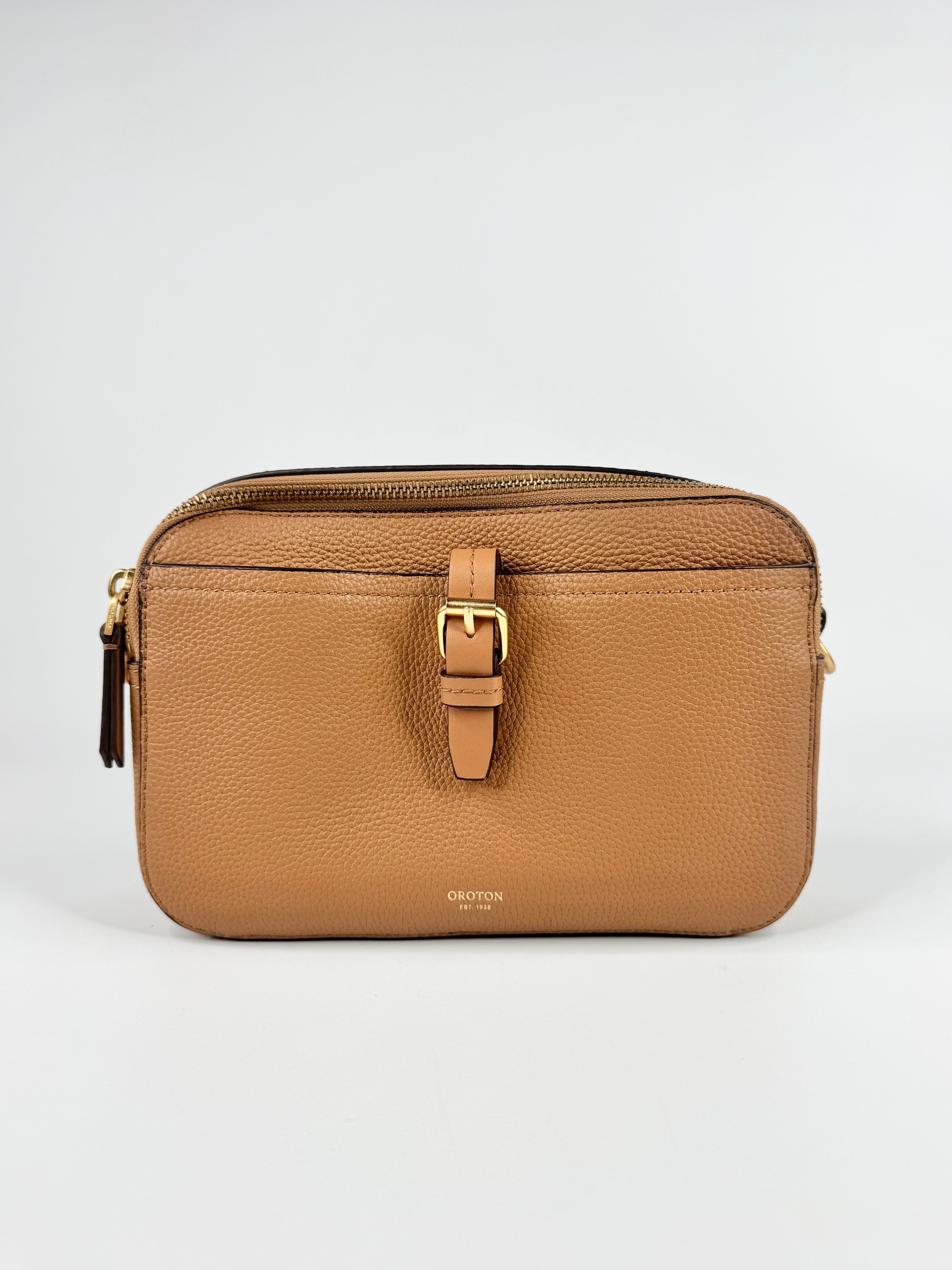 Brown leather bag with gold buckle on a white background