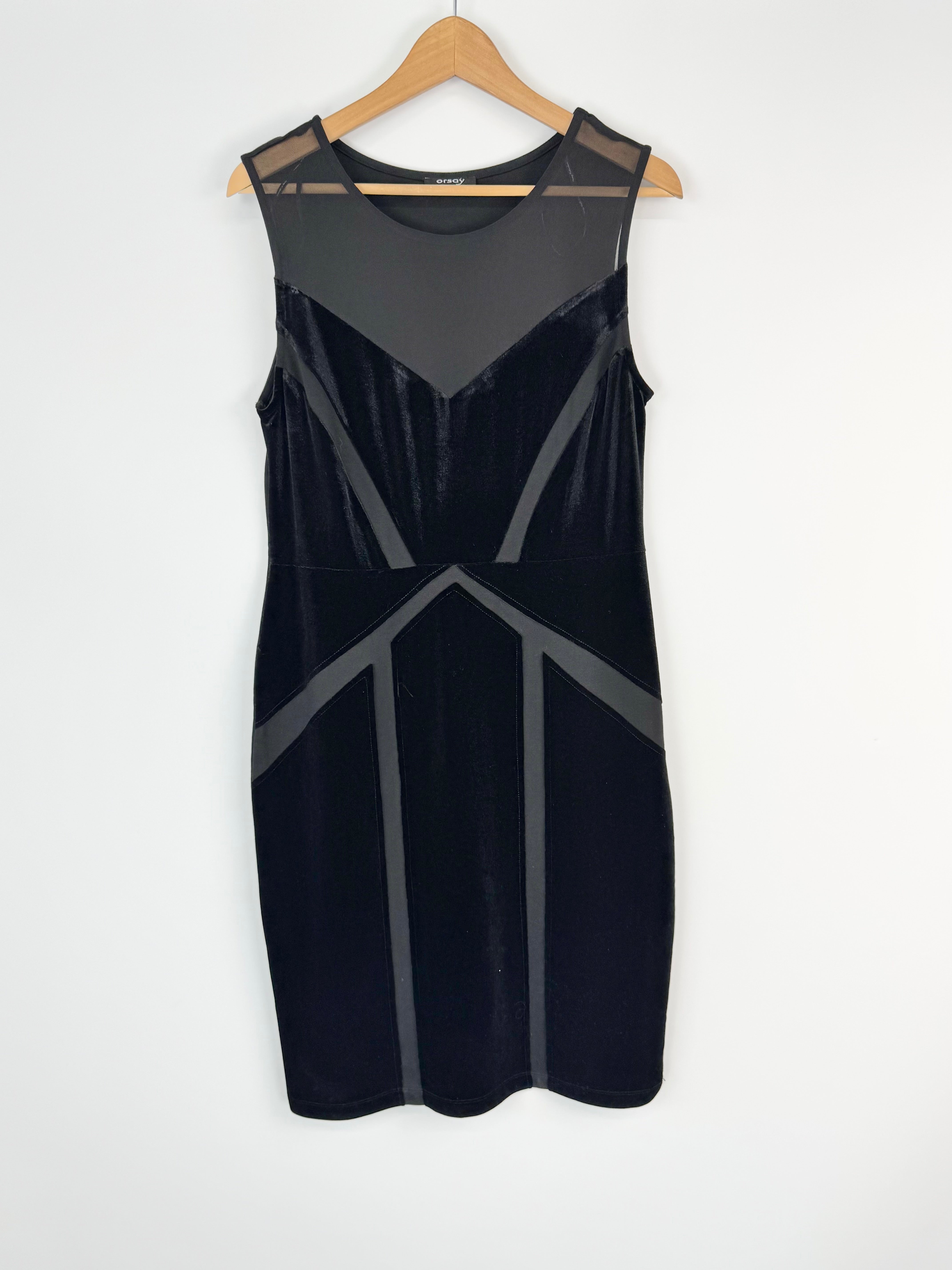 Black dress with geometric cutouts on a hanger against a white background