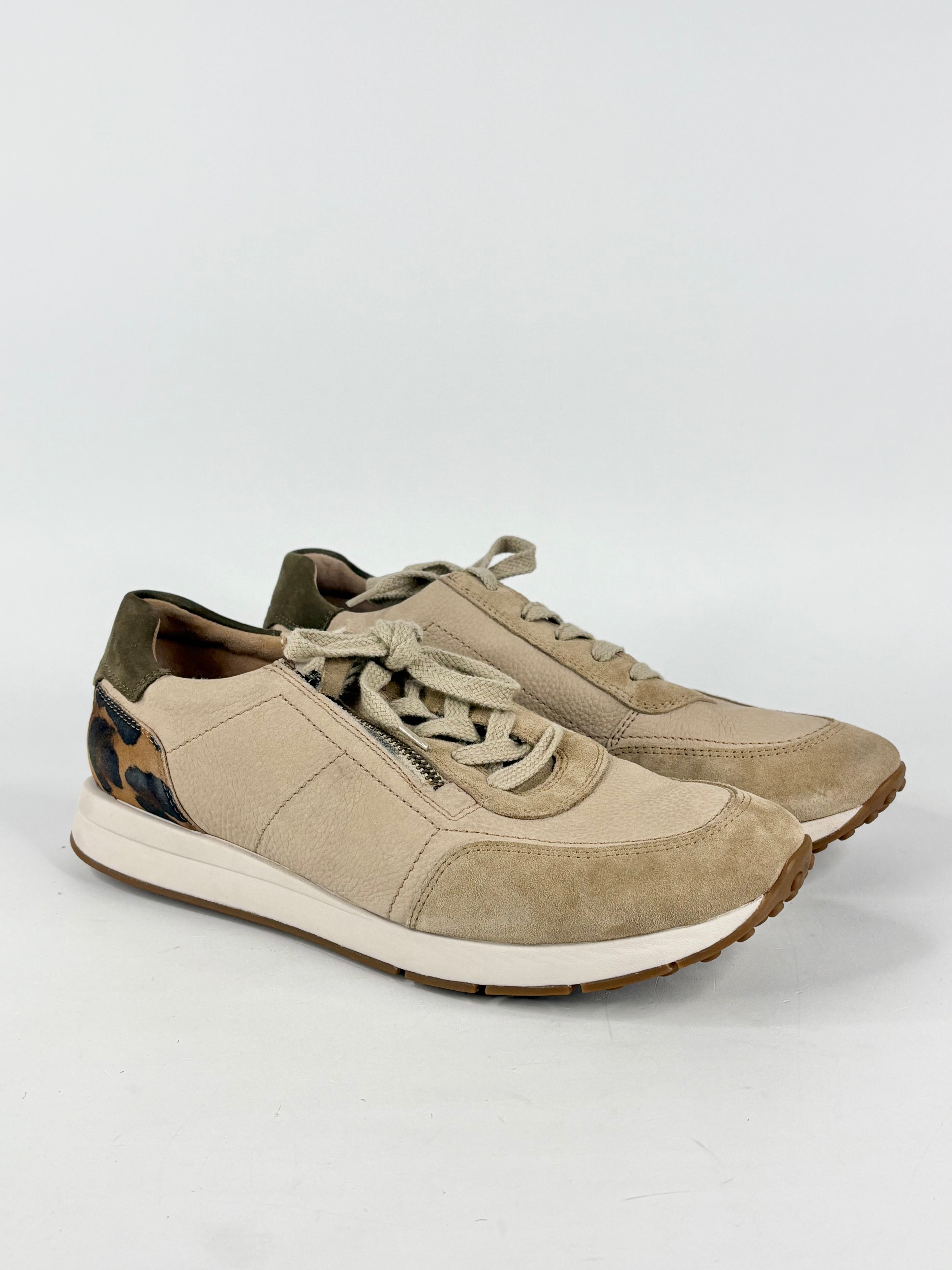 Beige sneakers with a patterned sole on a light gray background