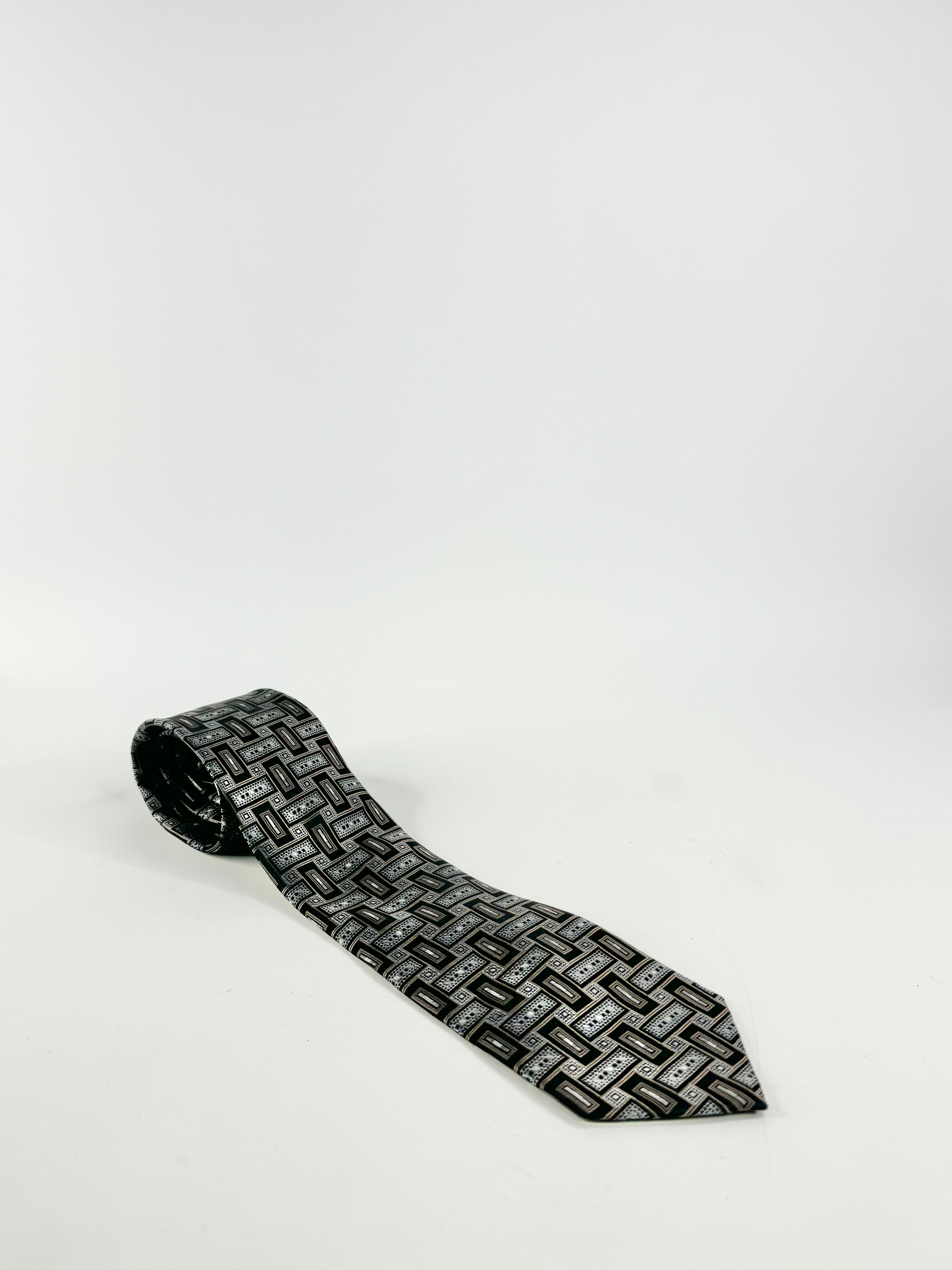 A black and grey patterned silk tie on a white background.