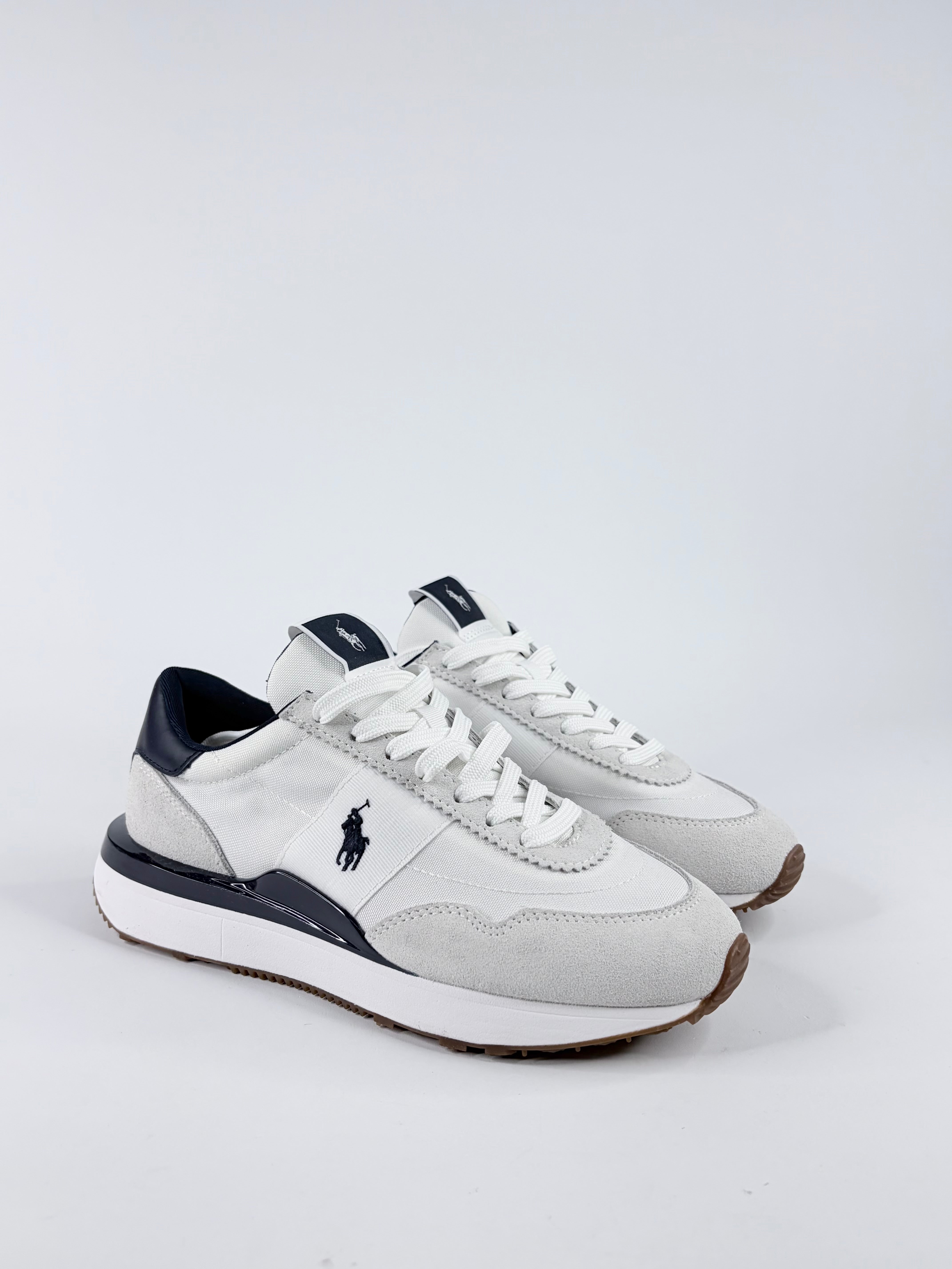 White sneakers with navy accents on a light gray background
