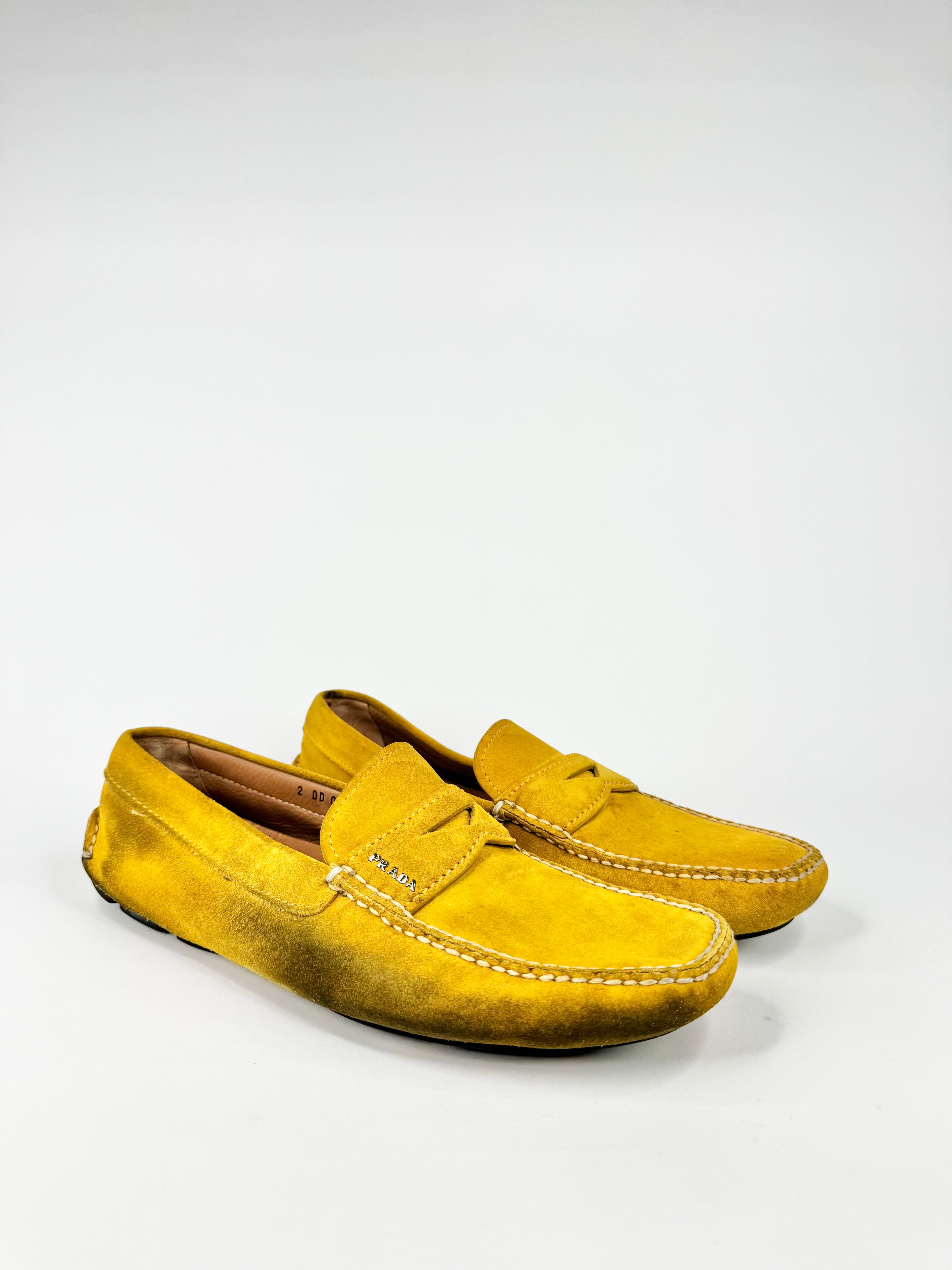 Pair of yellow suede loafers on a white background