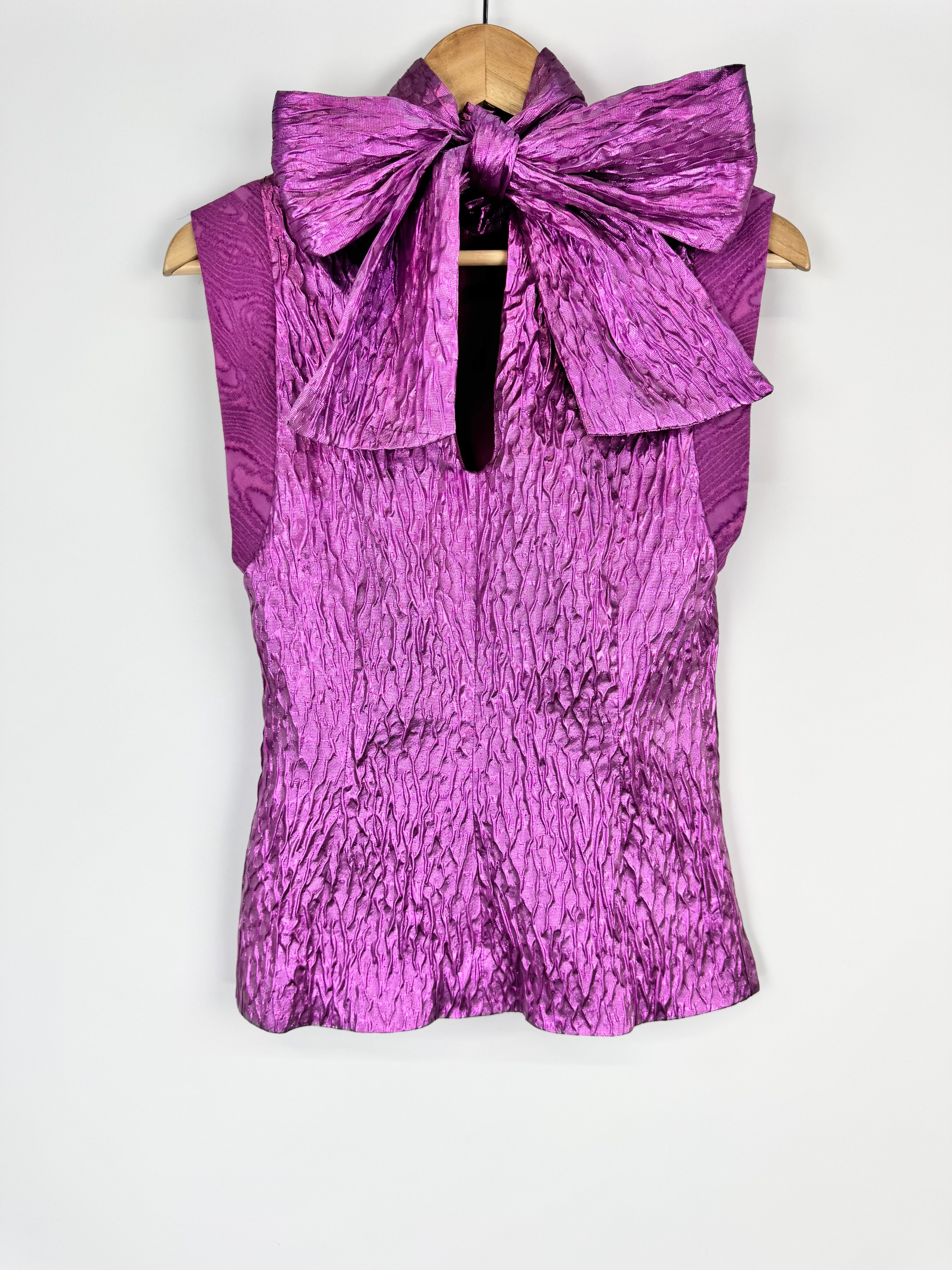 Purple textured top with a large bow on a white background