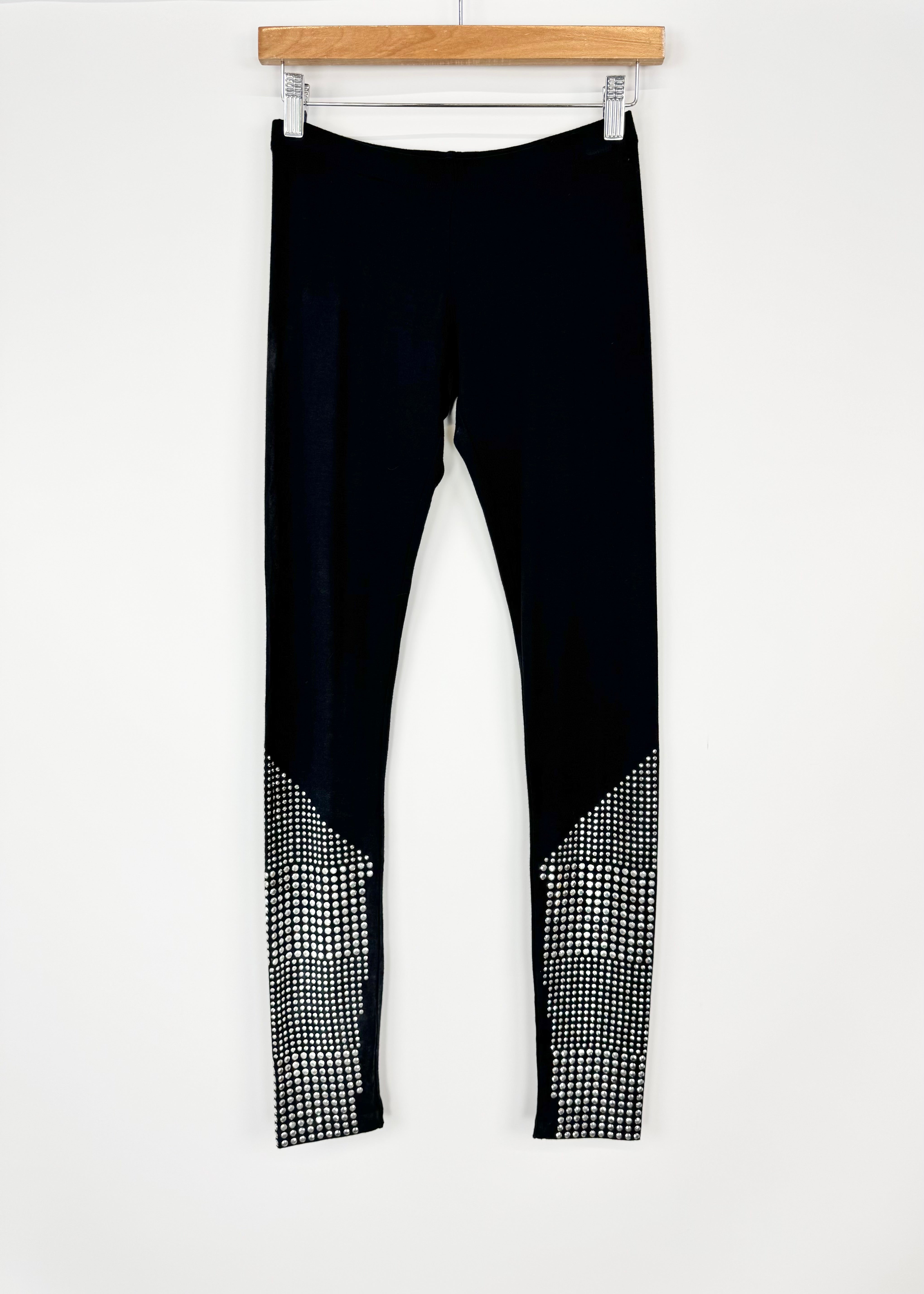Black leggings with geometric patterned cuffs on a white background
