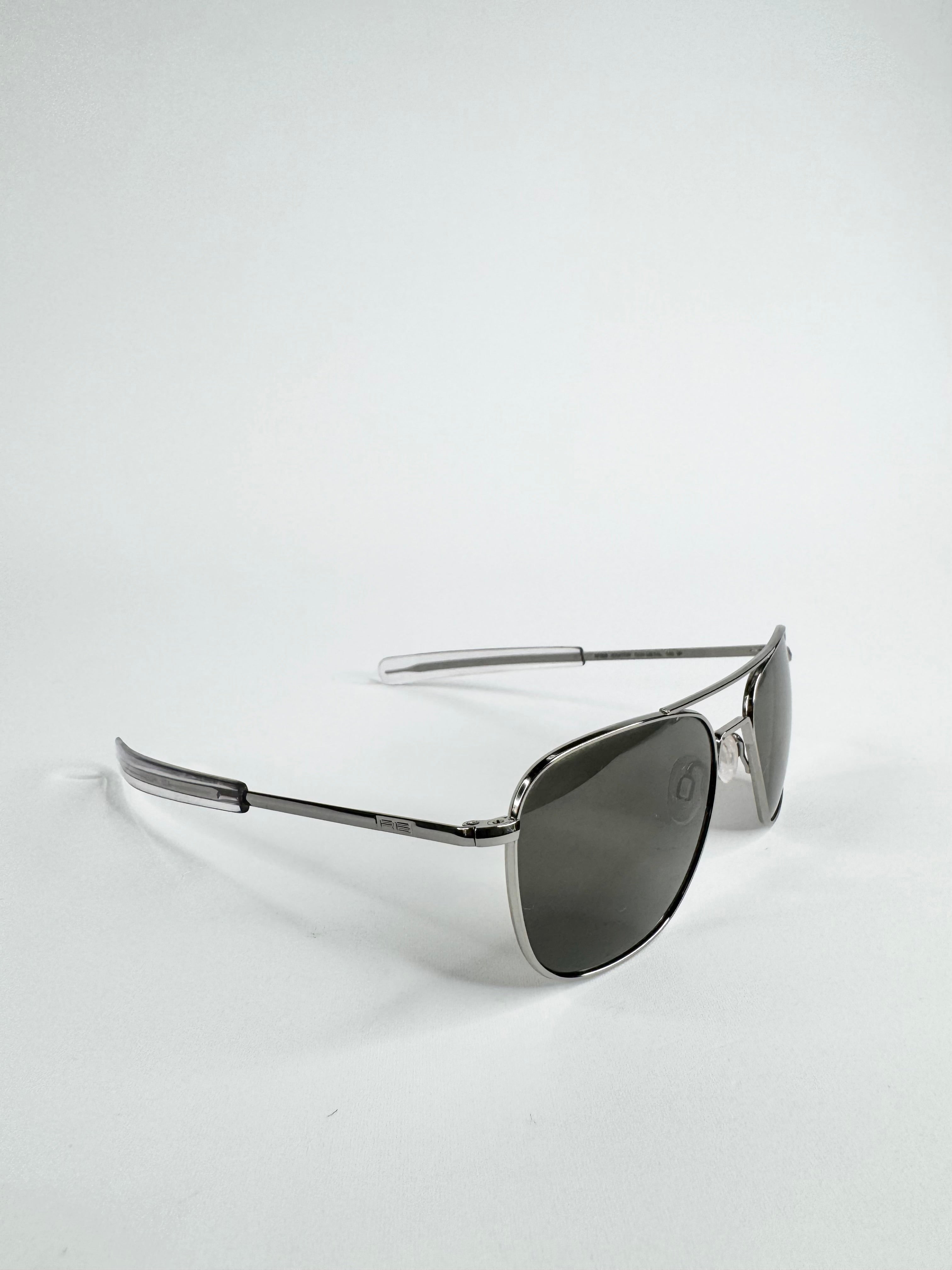 Sunglasses with metallic frame and dark lenses on a white background