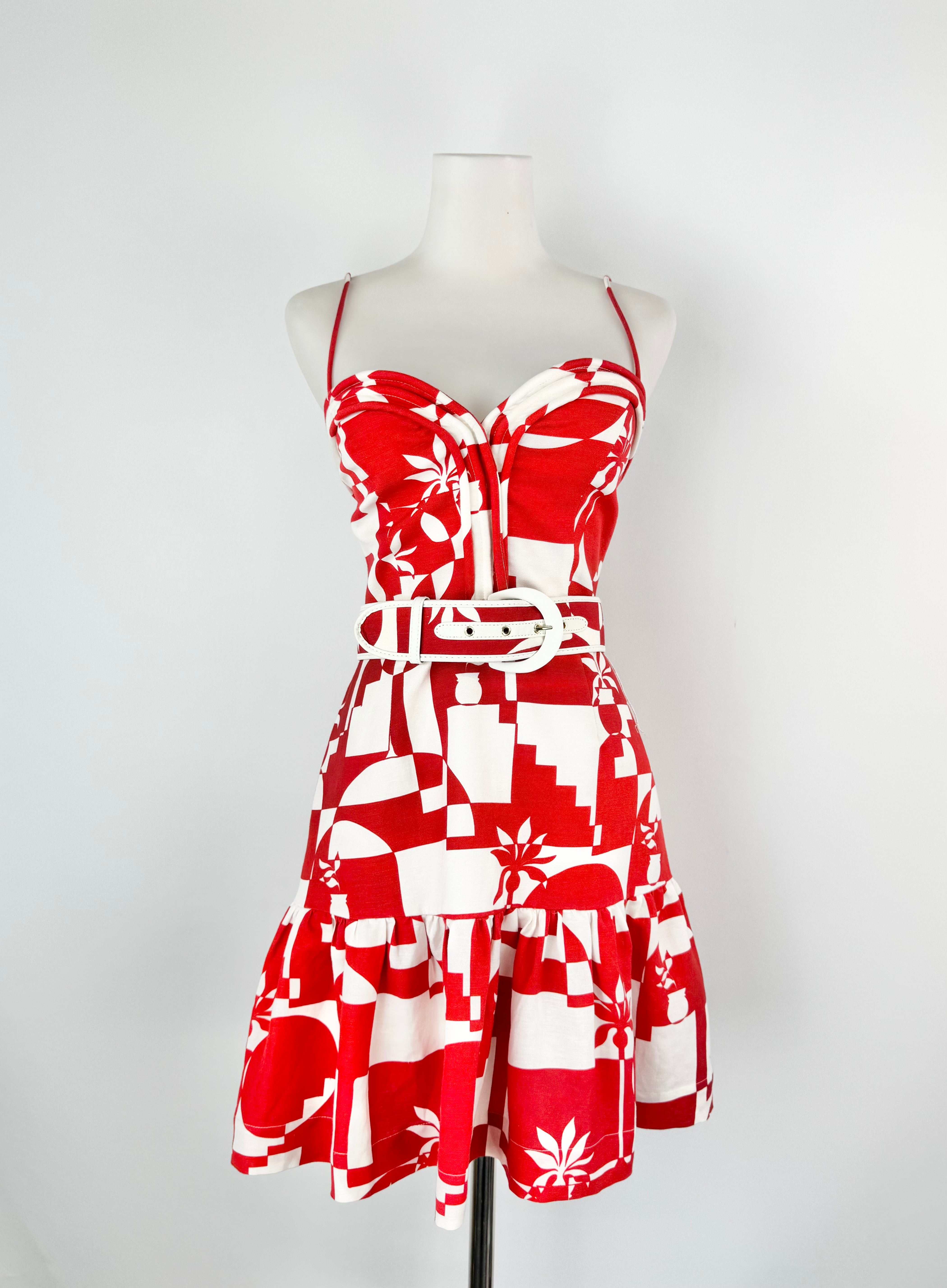 Red and white patterned dress on a mannequin against a white background