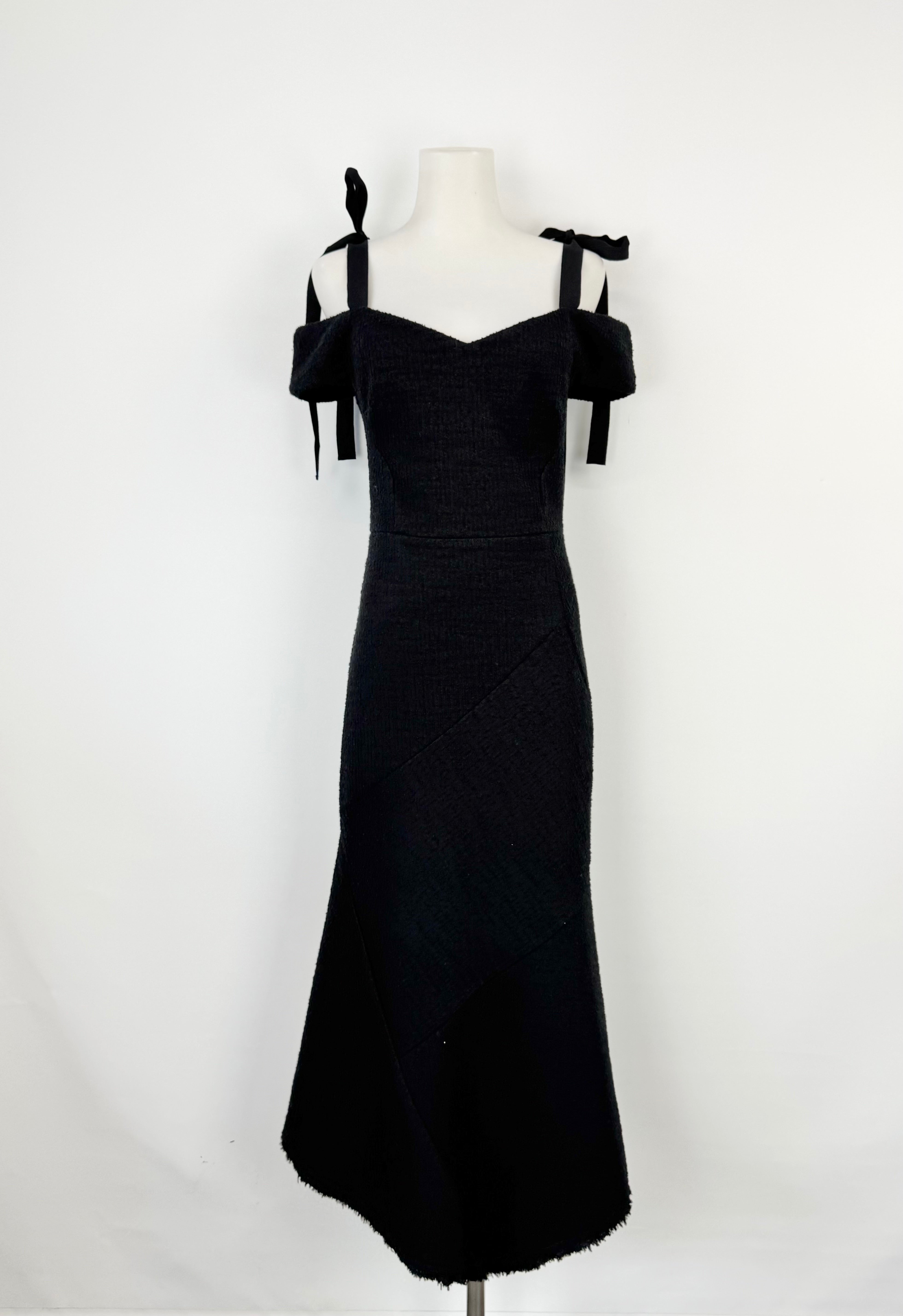 Black off-shoulder dress on a mannequin against a white background
