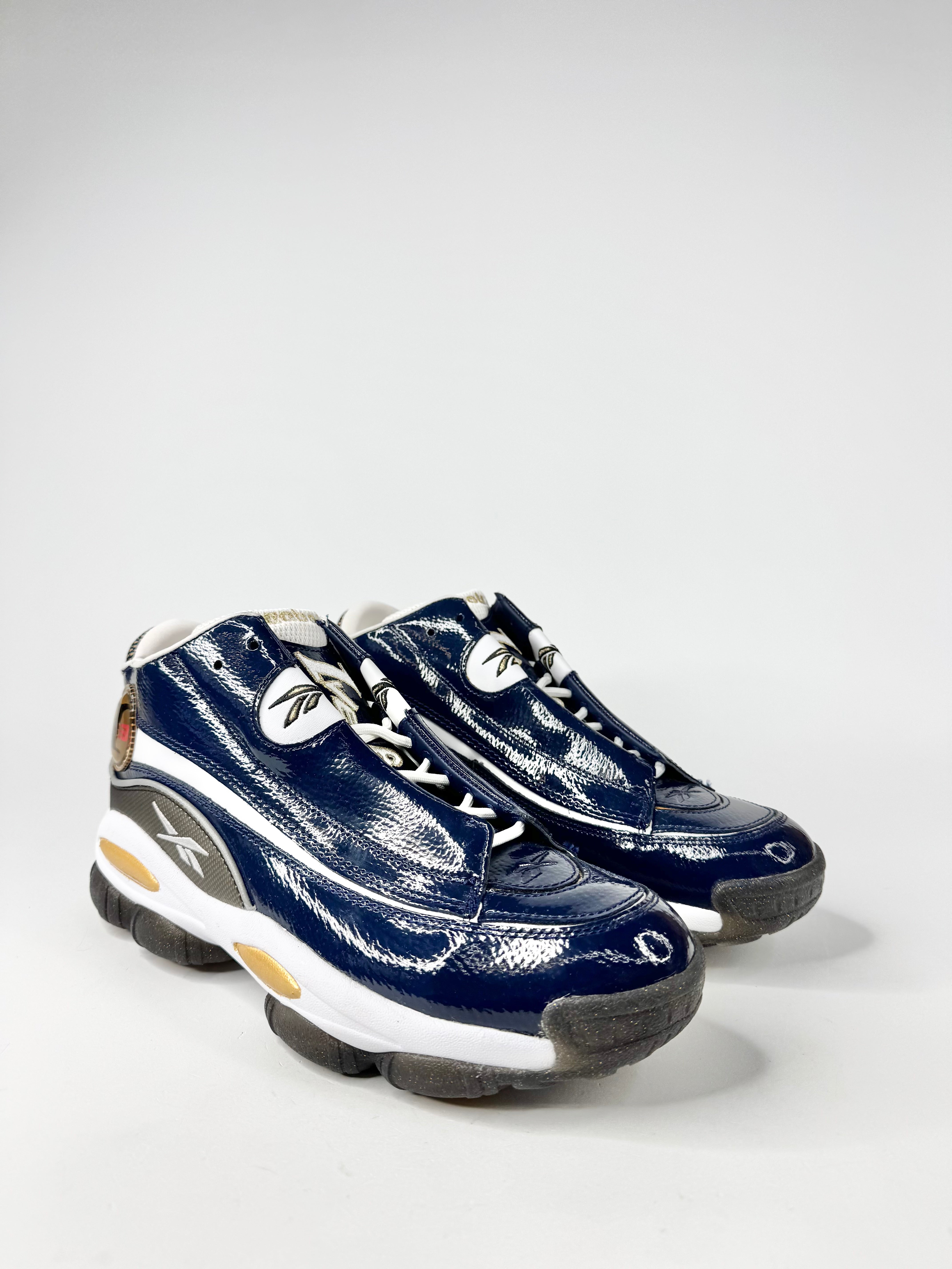Pair of blue sneakers with white soles on a light gray background