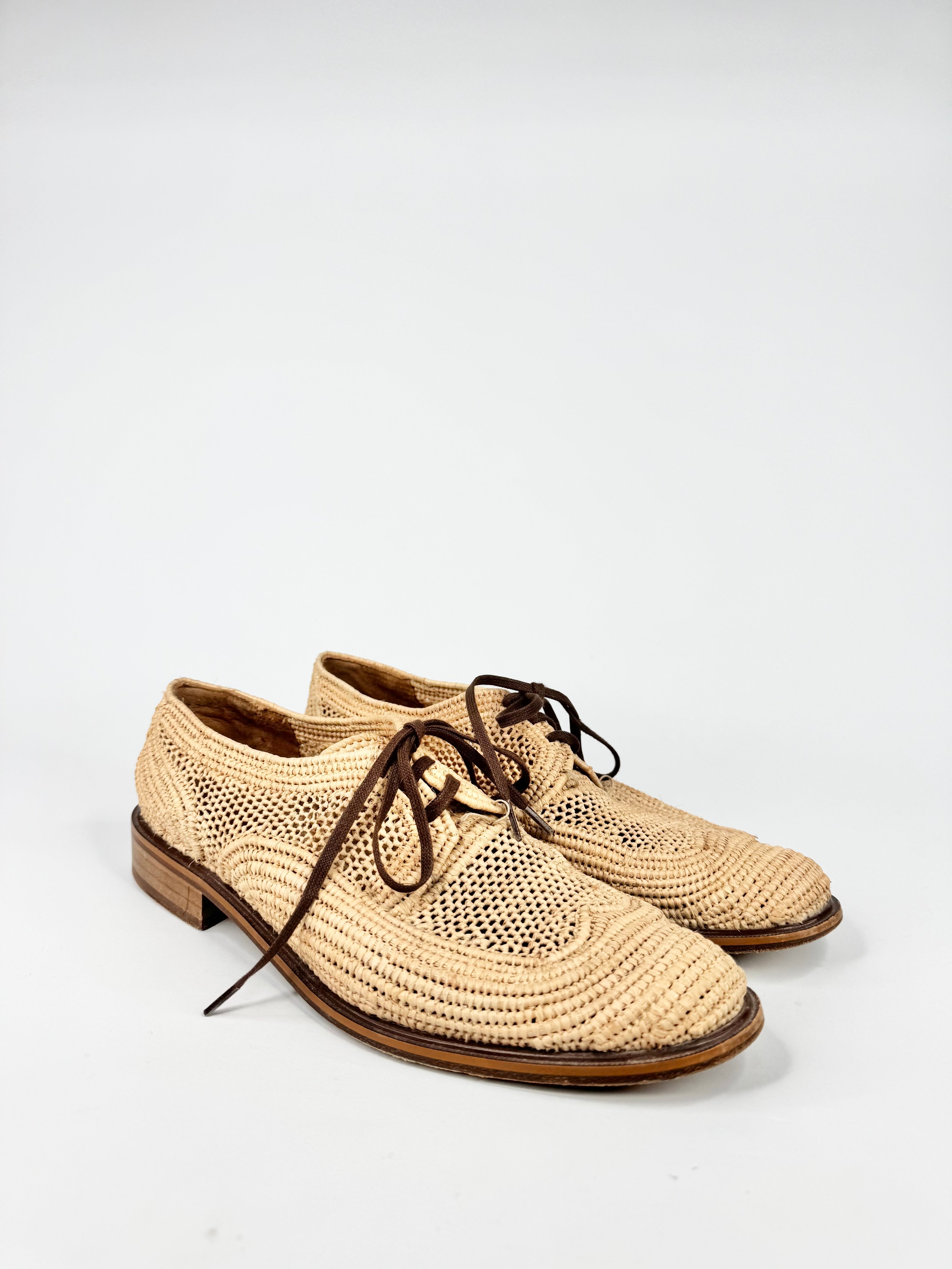 Pair of beige woven shoes on a white background