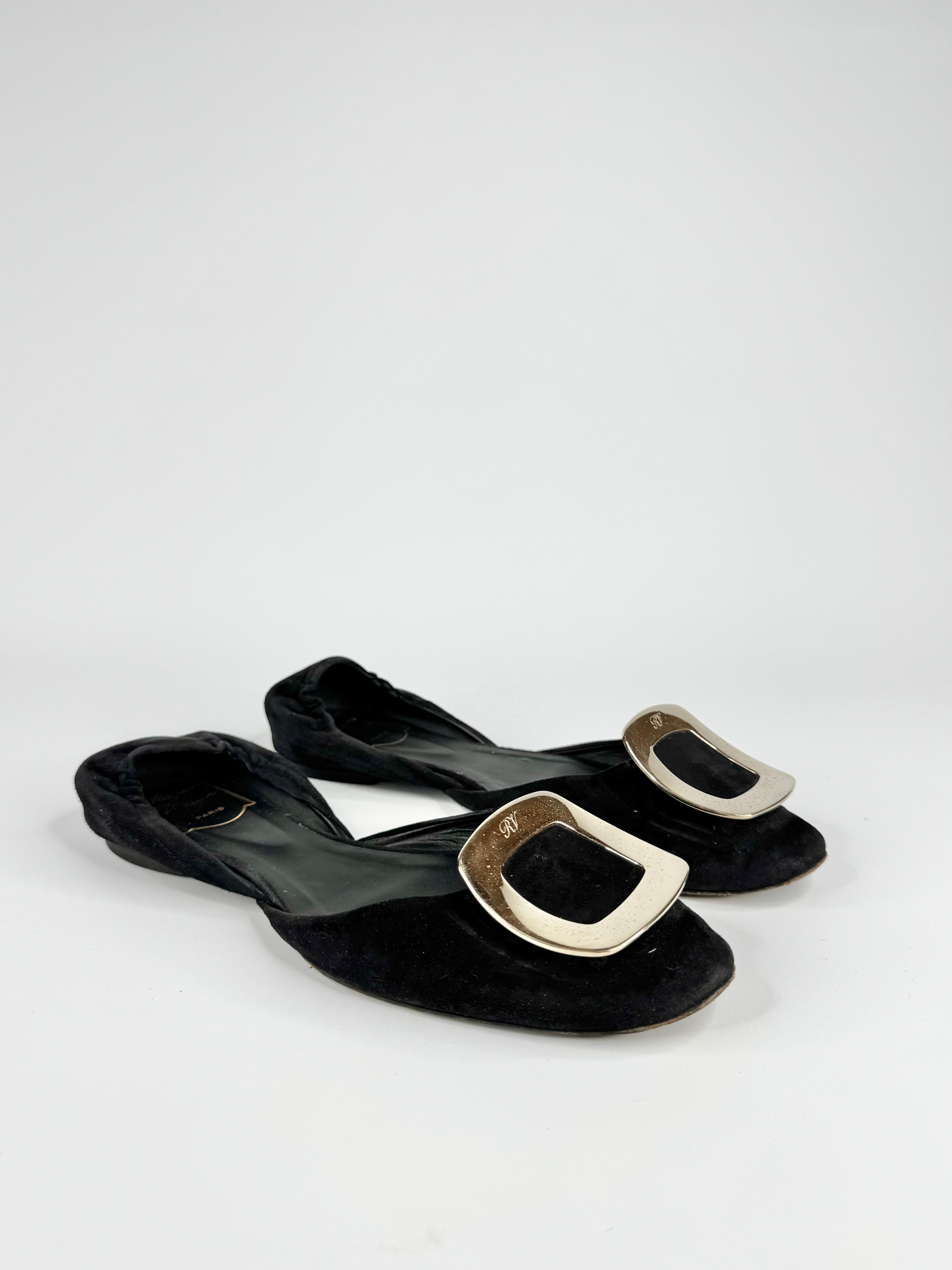 Black sandals with gold buckles on a white background