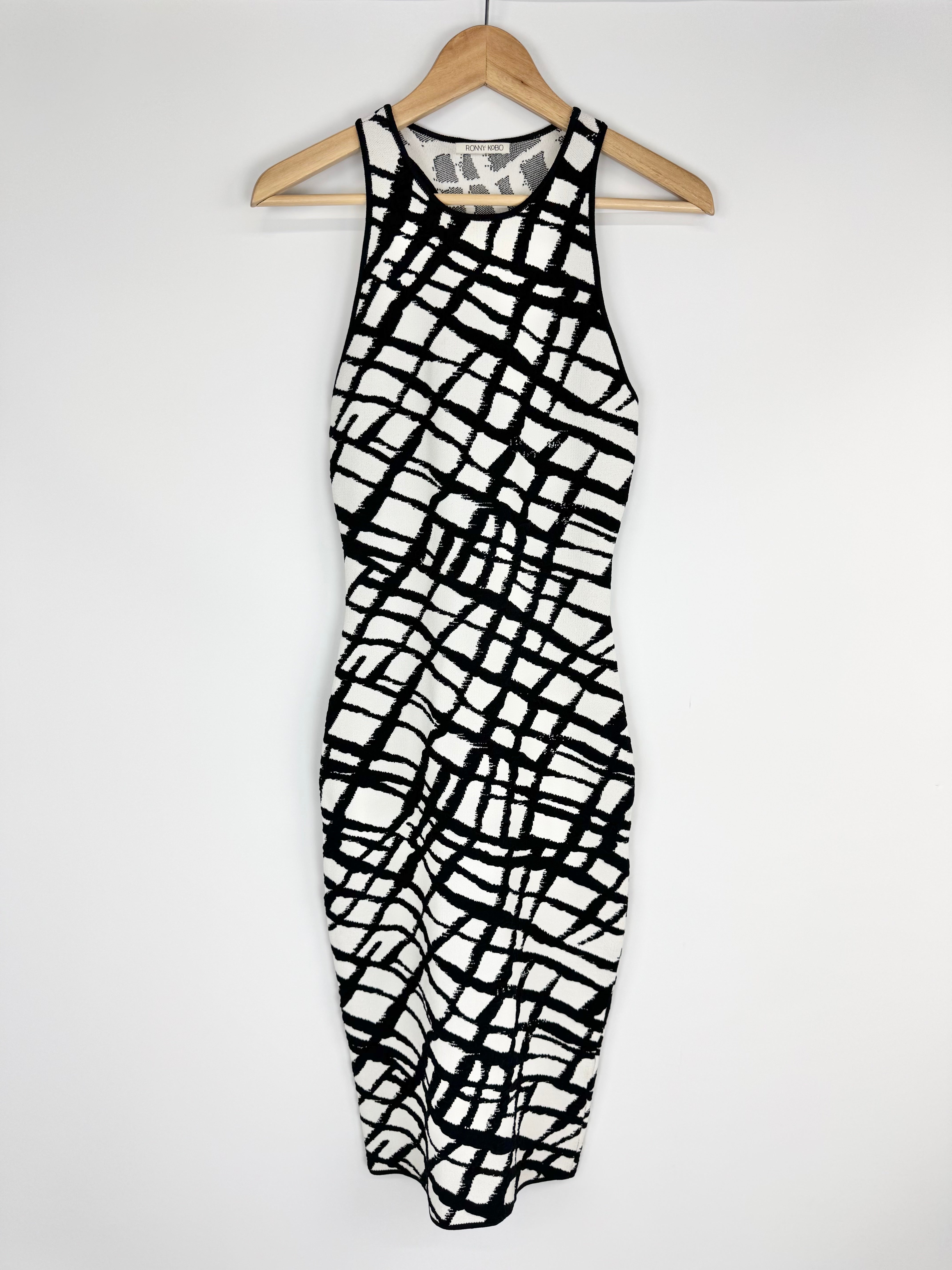 Black and white patterned dress on a hanger against a white background