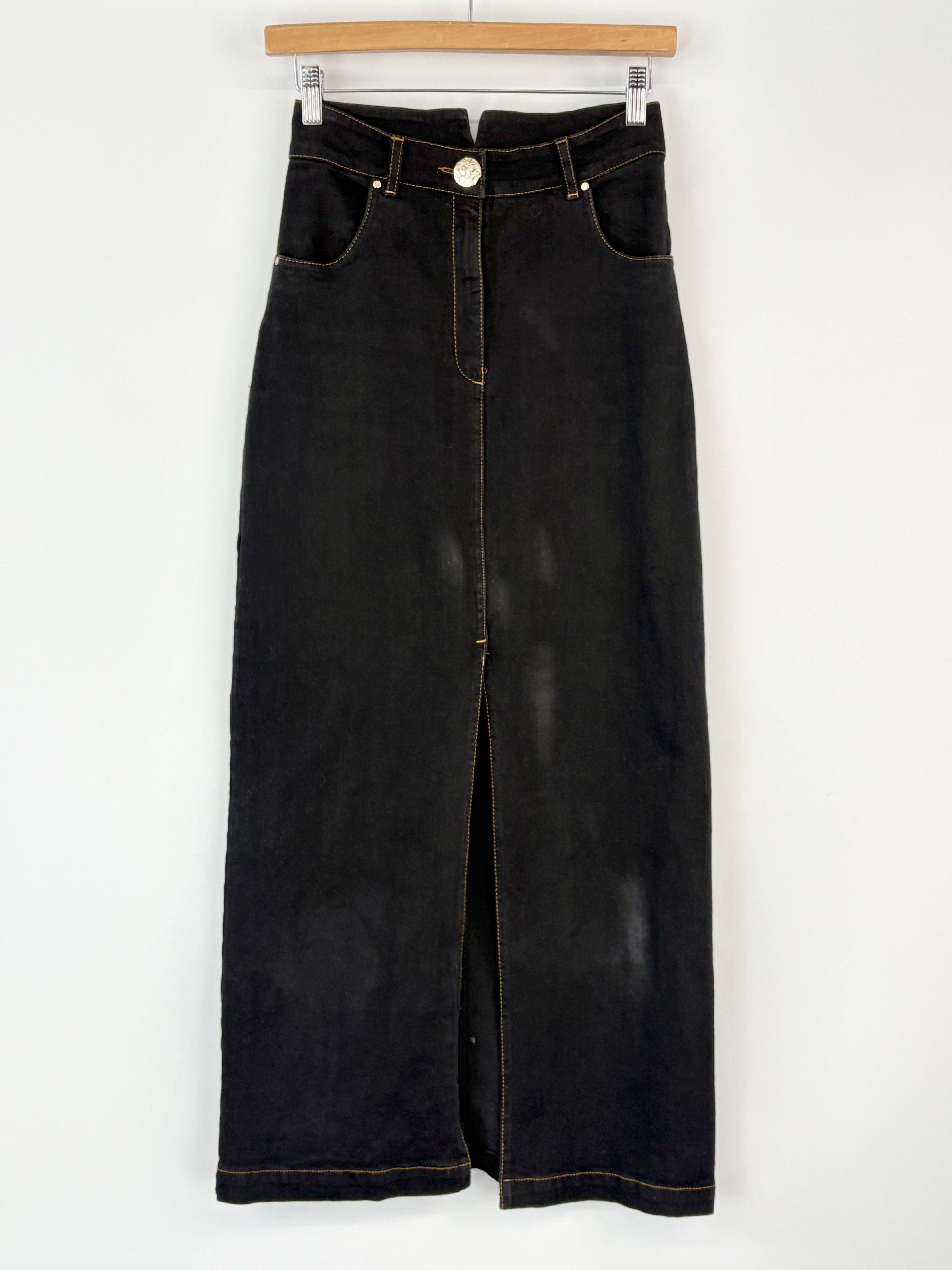 Black denim skirt on a hanger against a white background