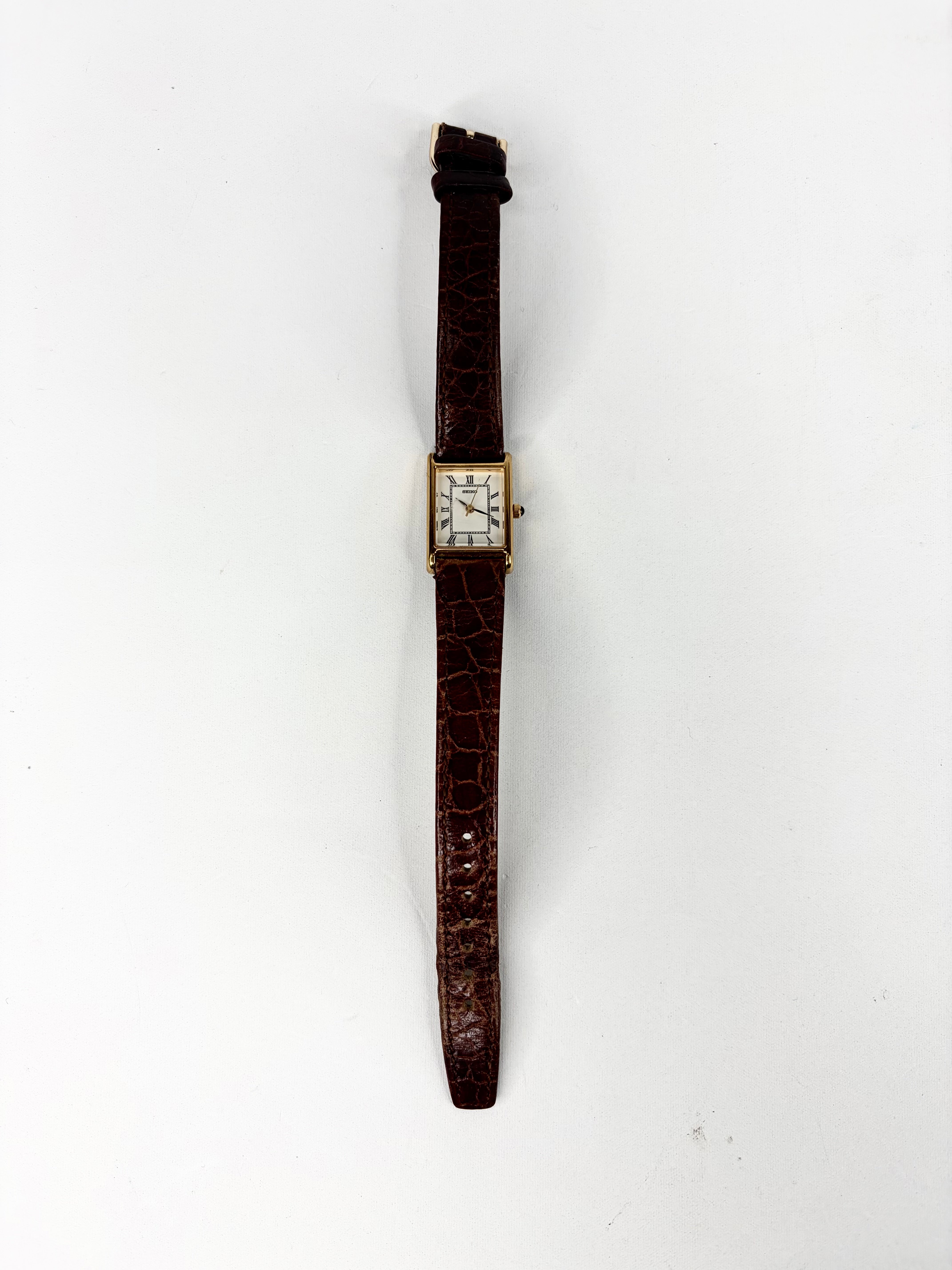 Vintage wristwatch with a brown strap on a white background