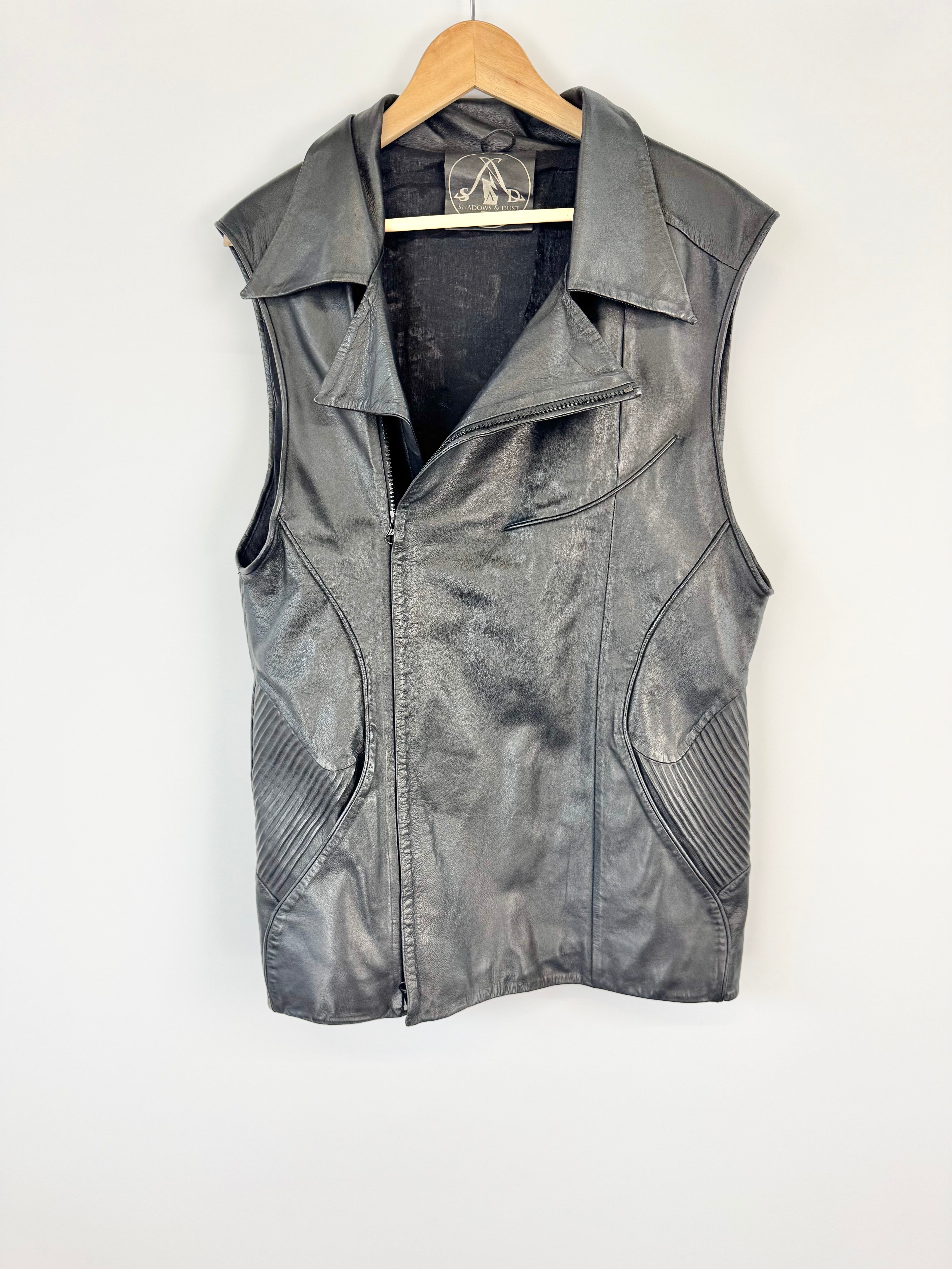 Gray leather vest on a hanger against a white background