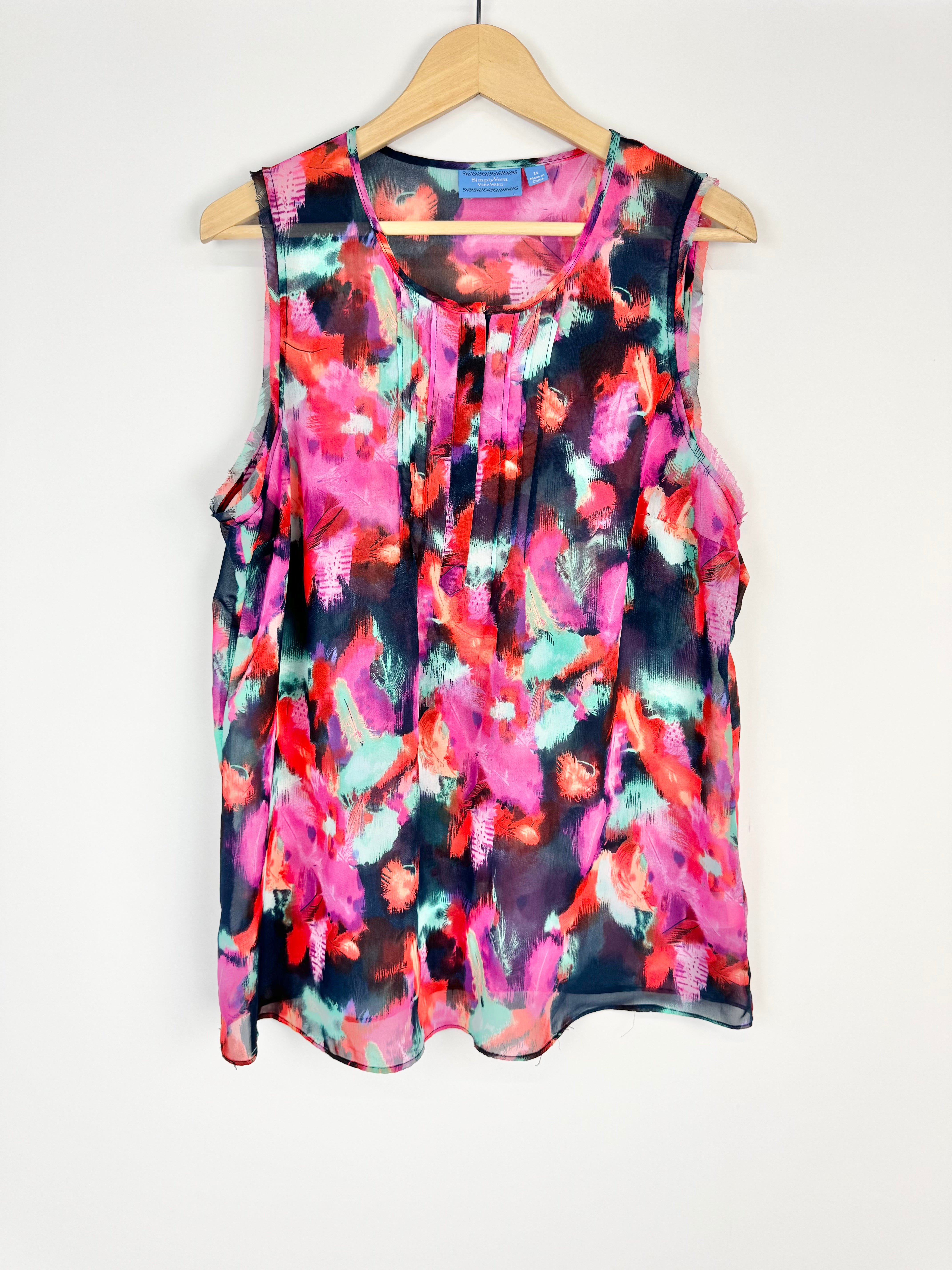 Multicolored sleeveless top on a hanger against a white background