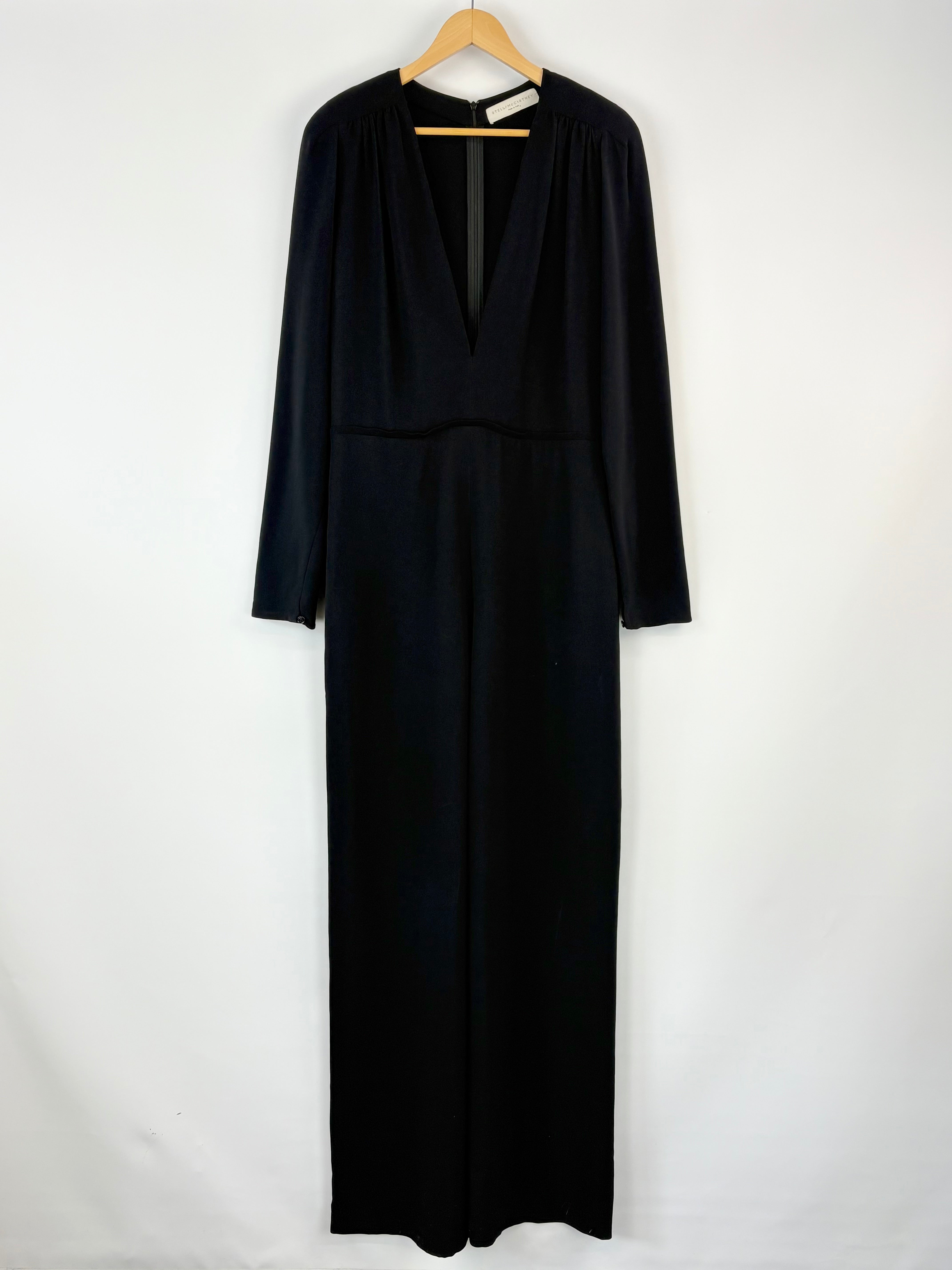 Black dress on a hanger against a white background