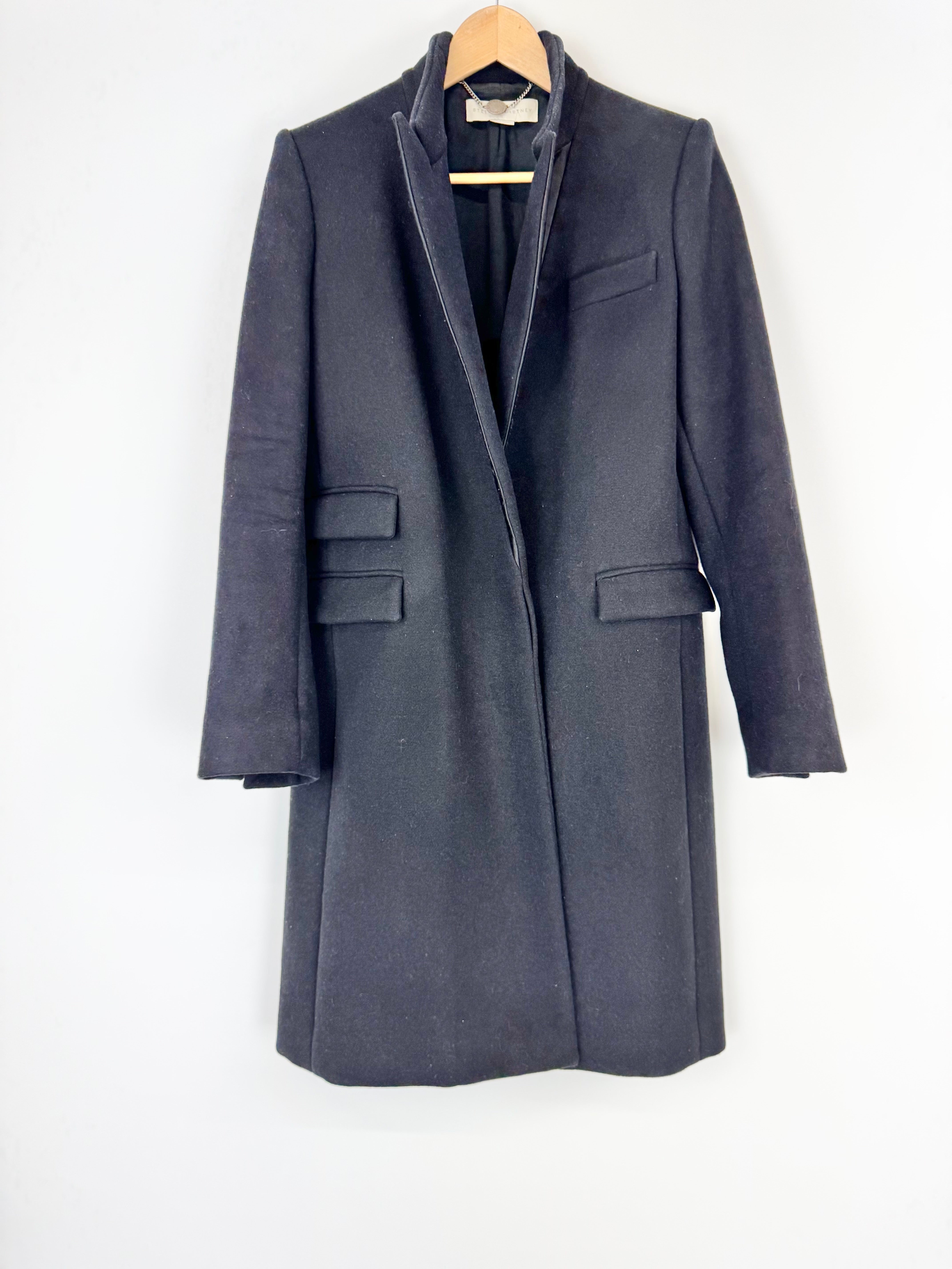Black coat on a hanger against a white background