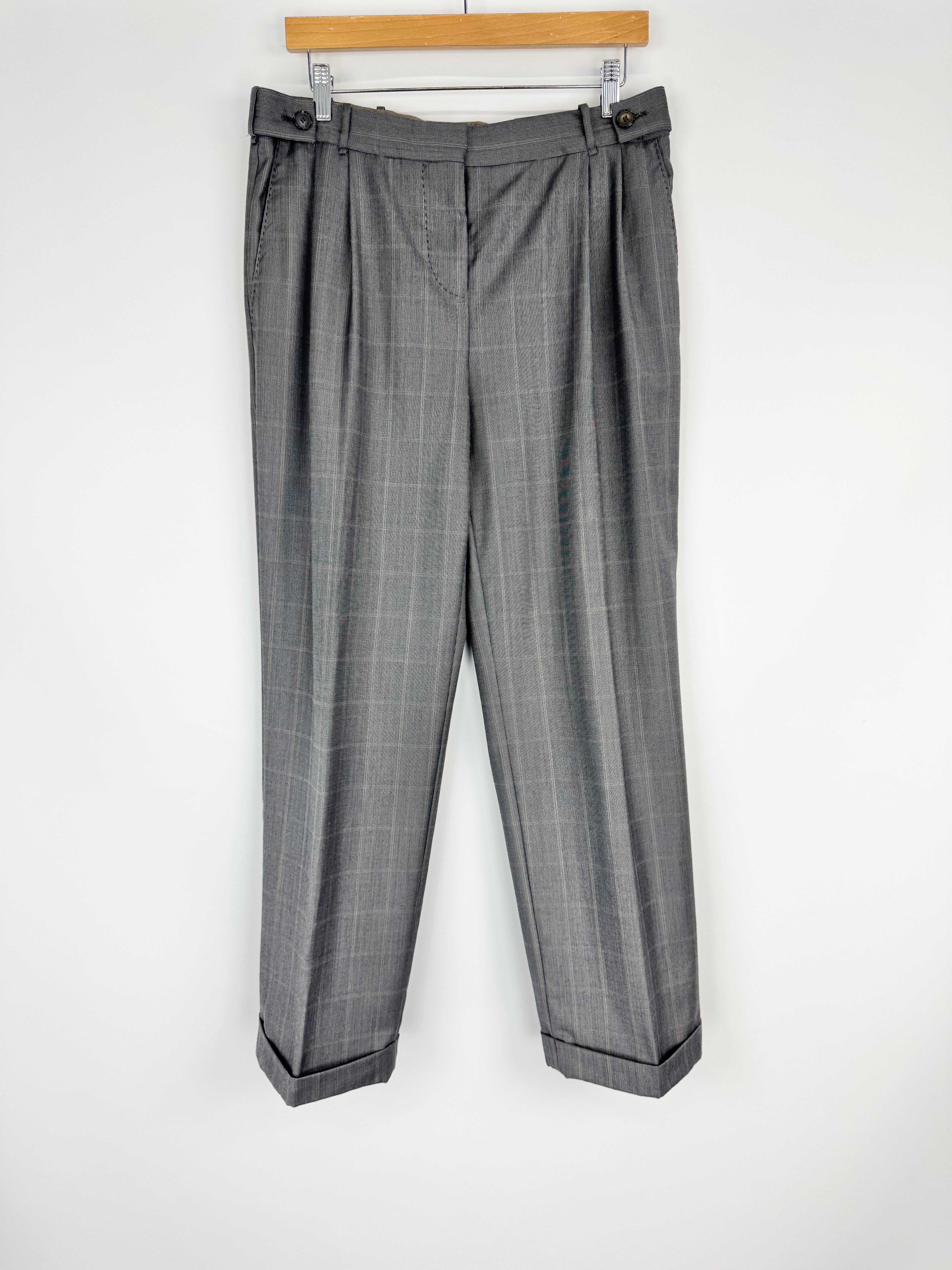Gray plaid pants on a hanger against a white background