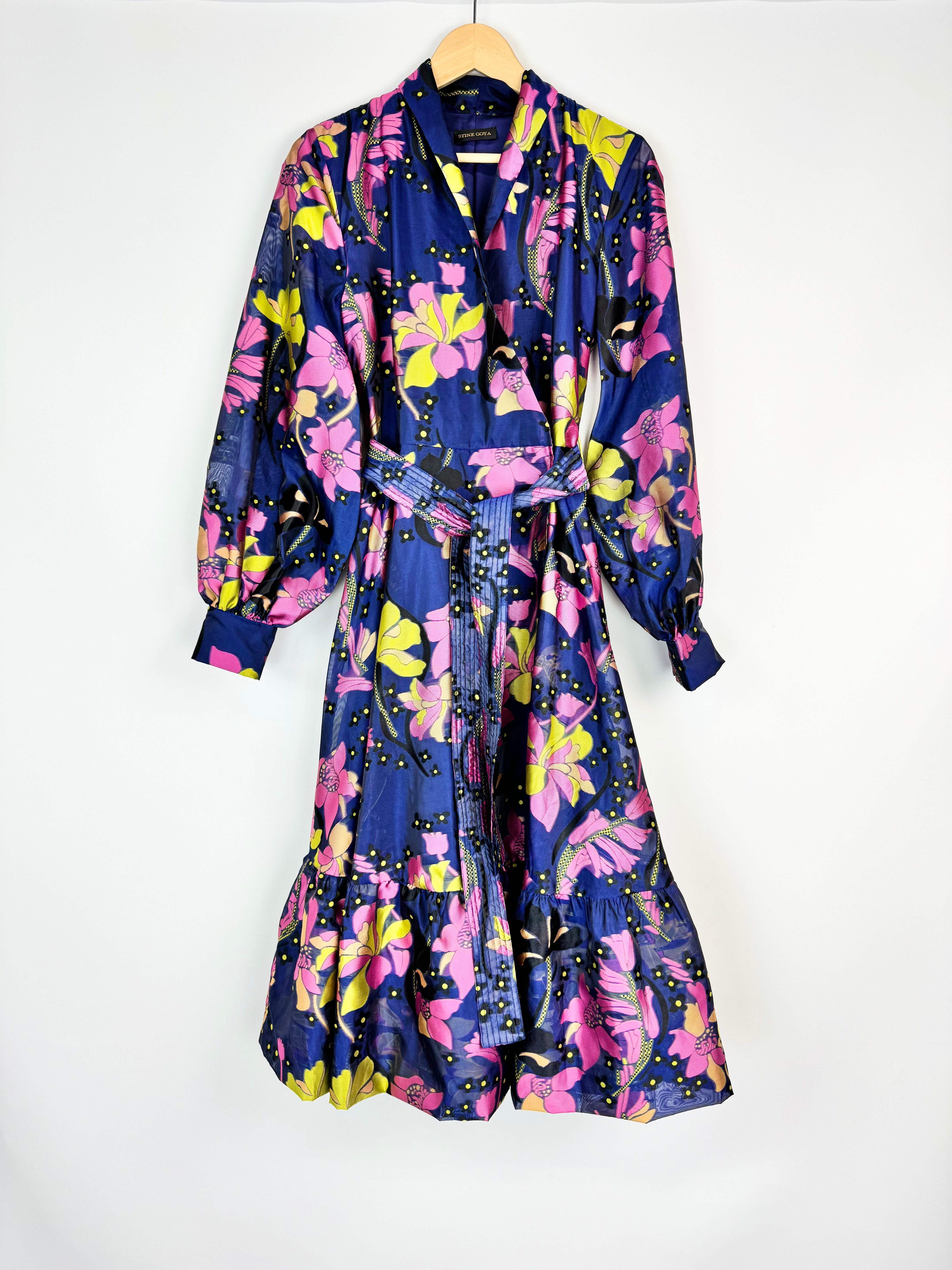 Floral patterned robe on a hanger against a white background