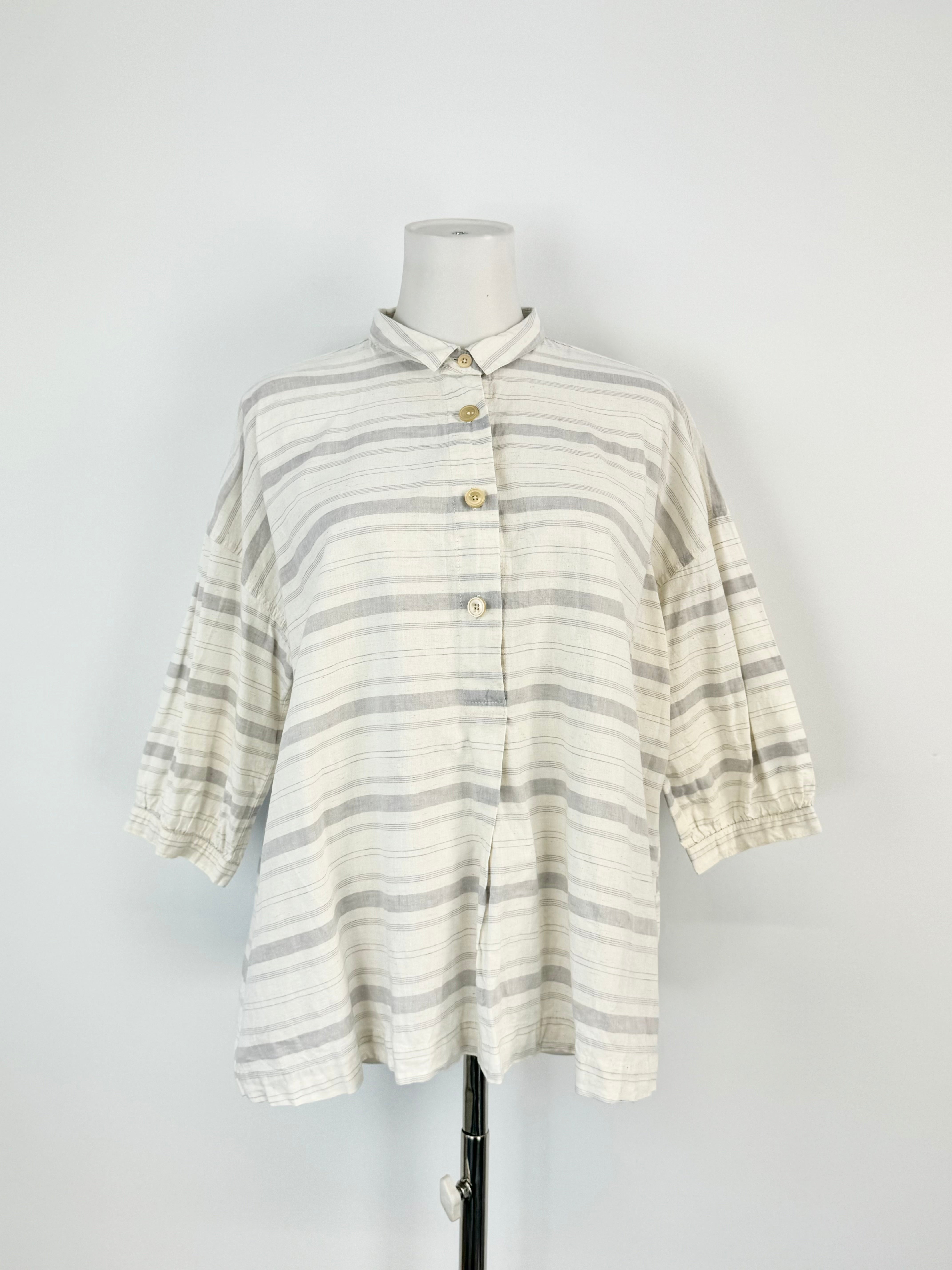 A striped, relaxed fit, short sleeve shirt on a mannequin, with the majority of the stripes in gray and a few in a lighter color, possibly white.