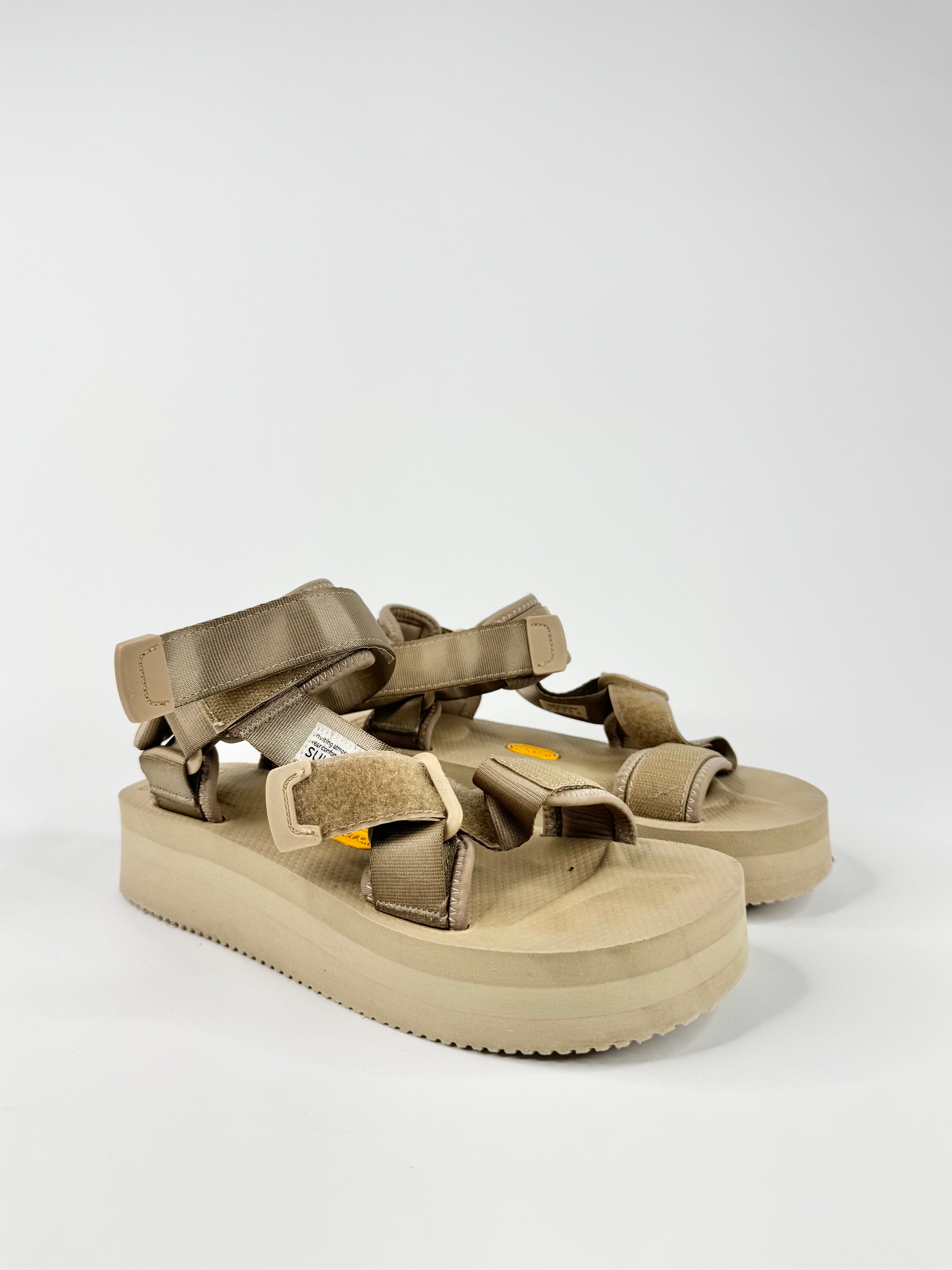 Beige sandals with multiple straps on a white background