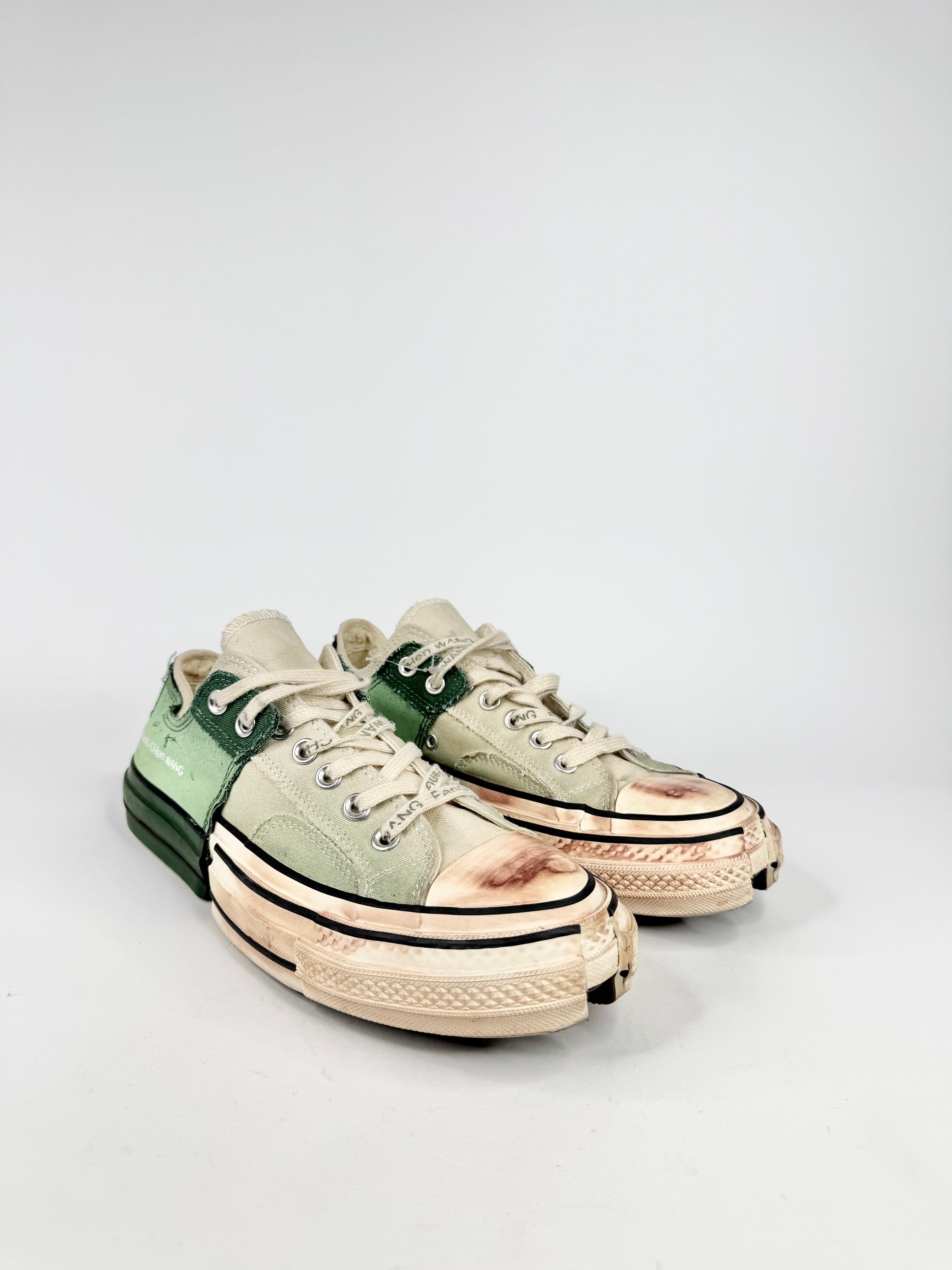 Pair of green and beige sneakers on a light gray background