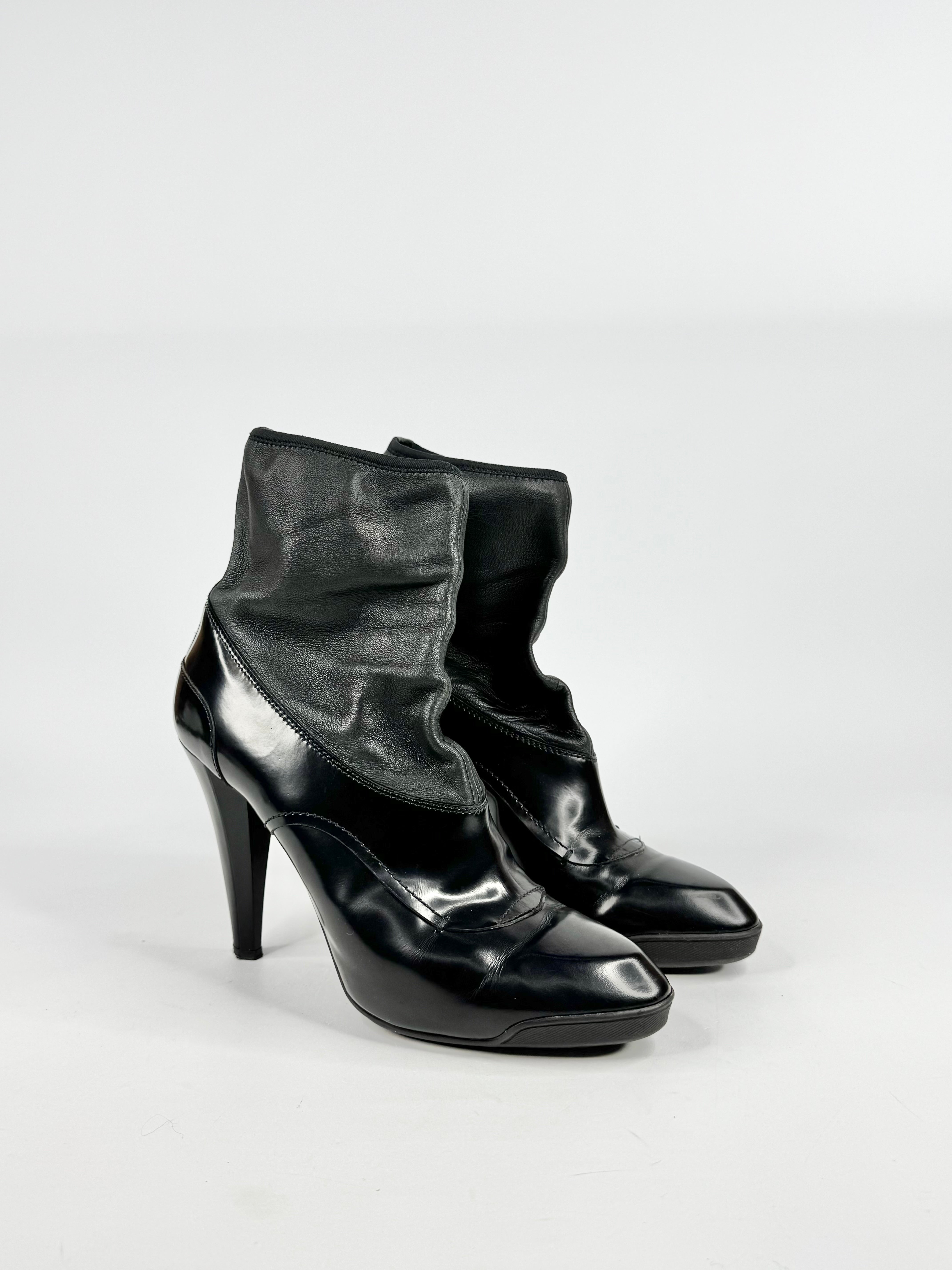 Black high-heeled shoes with ruffled tops on a white background