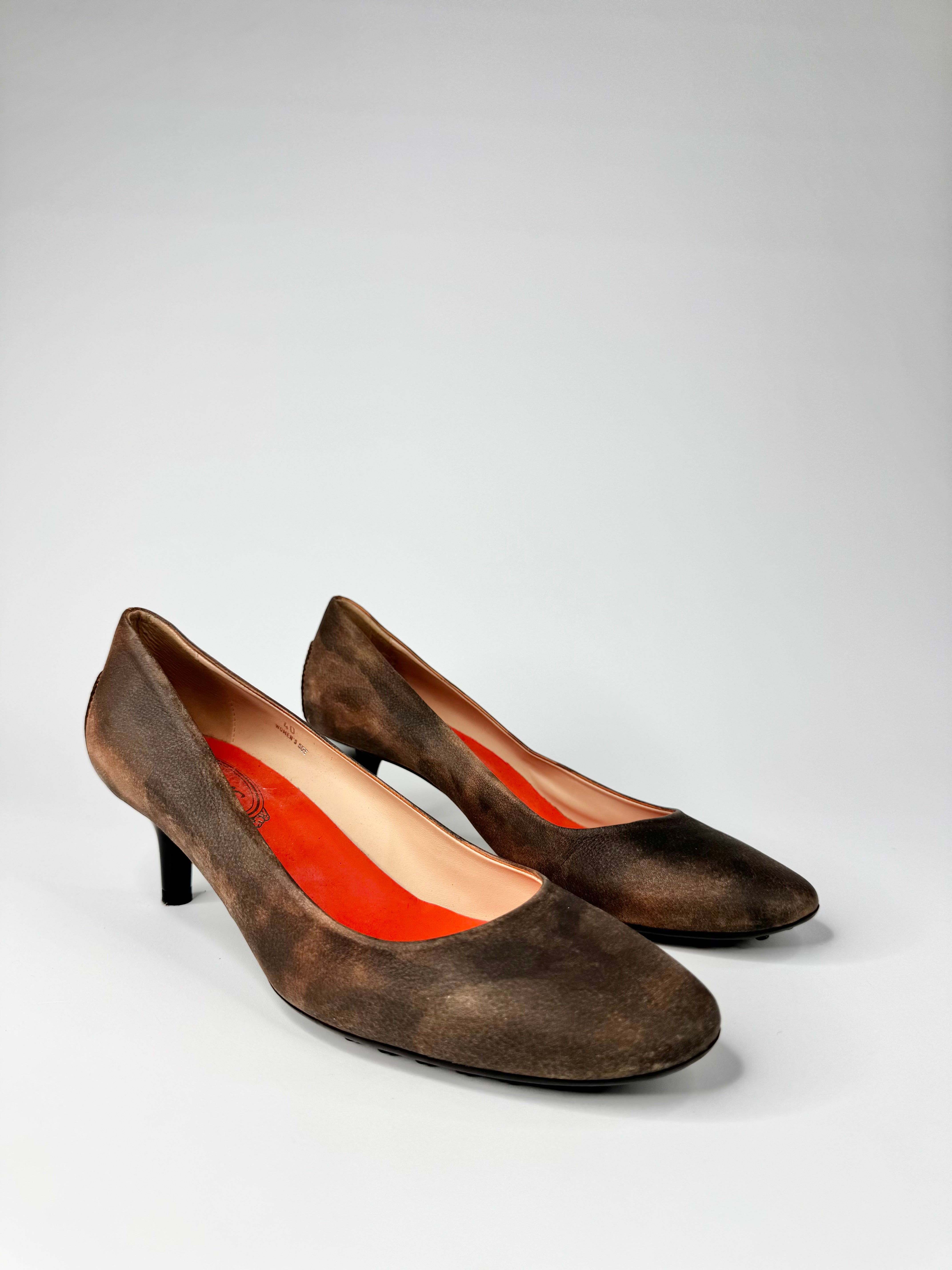 Pair of brown high-heeled shoes on a light gray background