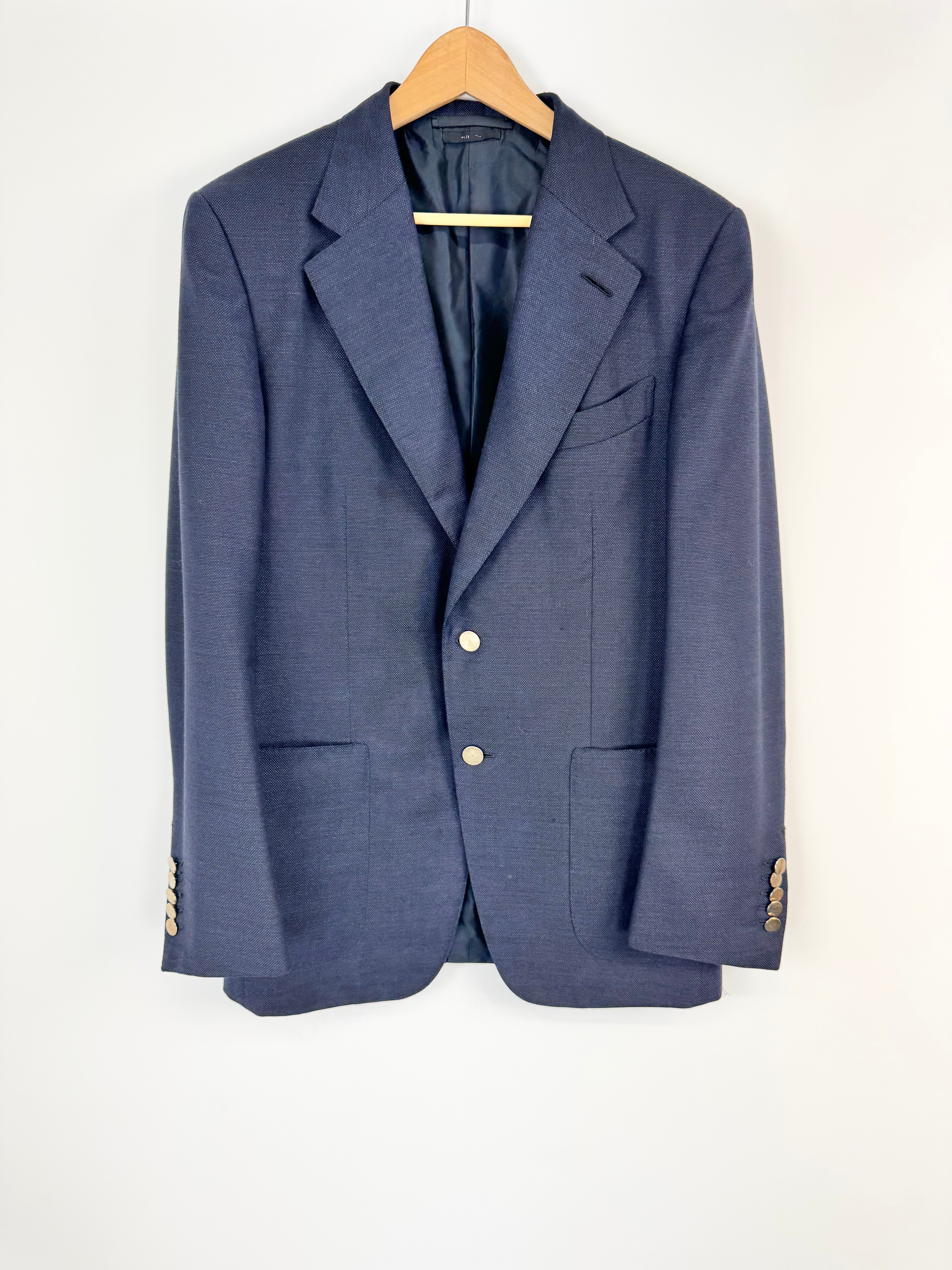 Blue blazer on a wooden hanger against a white background